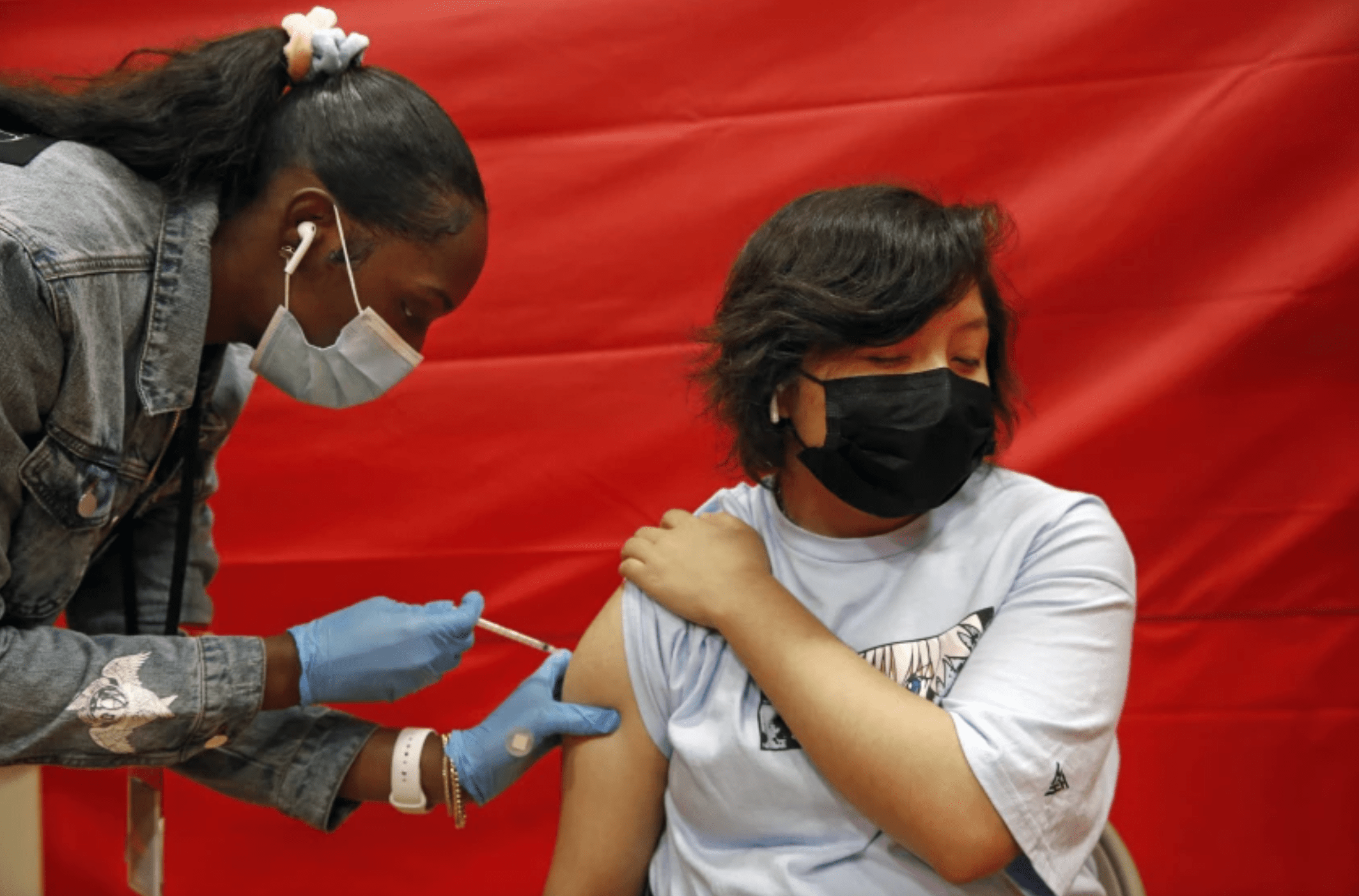 Alex Olvera, 15, is vaccinated against COVID-19 in a gym at Manual Arts High School, south of downtown on May 17, 2021. (Dania Maxwell / Los Angeles Times)