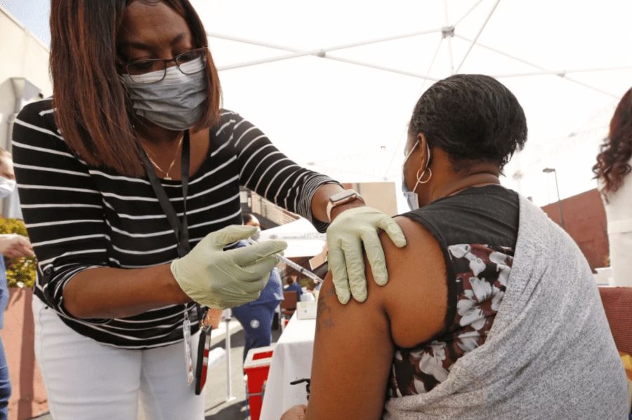 Hadizatou Toure, 35, receives the Pfizer COVID-19 vaccination from registered nurse Janice Taylor in Los Angeles in April. (Al Seib / Los Angeles Times)