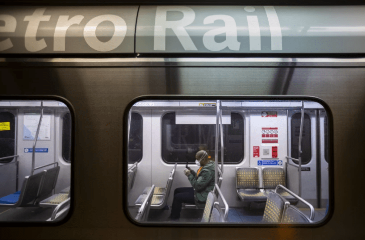 A man sits in a nearly empty train car on the Metro Blue Line at the 7th and Metro station in Los Angeles last year. (Brian van der Brug / Los Angeles Times)