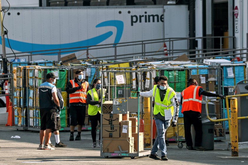 Delivery vans leave an Amazon warehouse facility in Hawthorne in this undated photo. The company is being fined by Cal OSHA for COVID-19 workplace safety failings in a second round of California citations in May 2021. (Irfan Khan / Los Angeles Times)