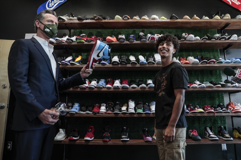 During a visit to downtown Los Angeles, in April 2021, Gov. Gavin Newsom meets Mario Rodriguez of Hype Beast Kicks shoe store. (Robert Gauthier/Los Angeles Times)