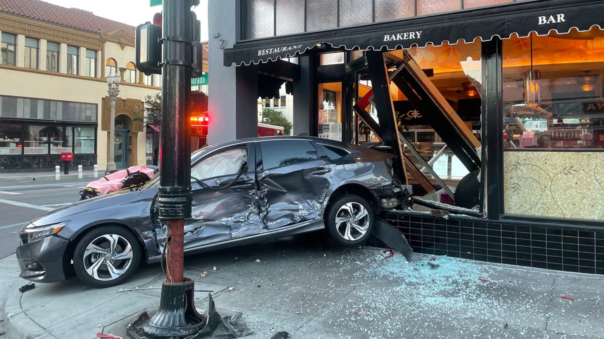 A car careened into the storefront of the Cheesecake Factory in Old Town Pasadena on Tuesday morning after a collision in an intersection.(Pasadena Fire Department )