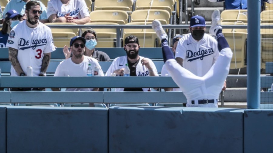 Fans watch as Dodgers second baseman Zach McKinstry takes a tumble while vainly chasing a foul ball during a game against the Washington Nationals on April 9 at Dodger Stadium. A statewide survey that found the majority of Californians are in support of allowing entertainment venues to require vaccine verification of its patrons.(Robert Gauthier / Los Angeles Times)