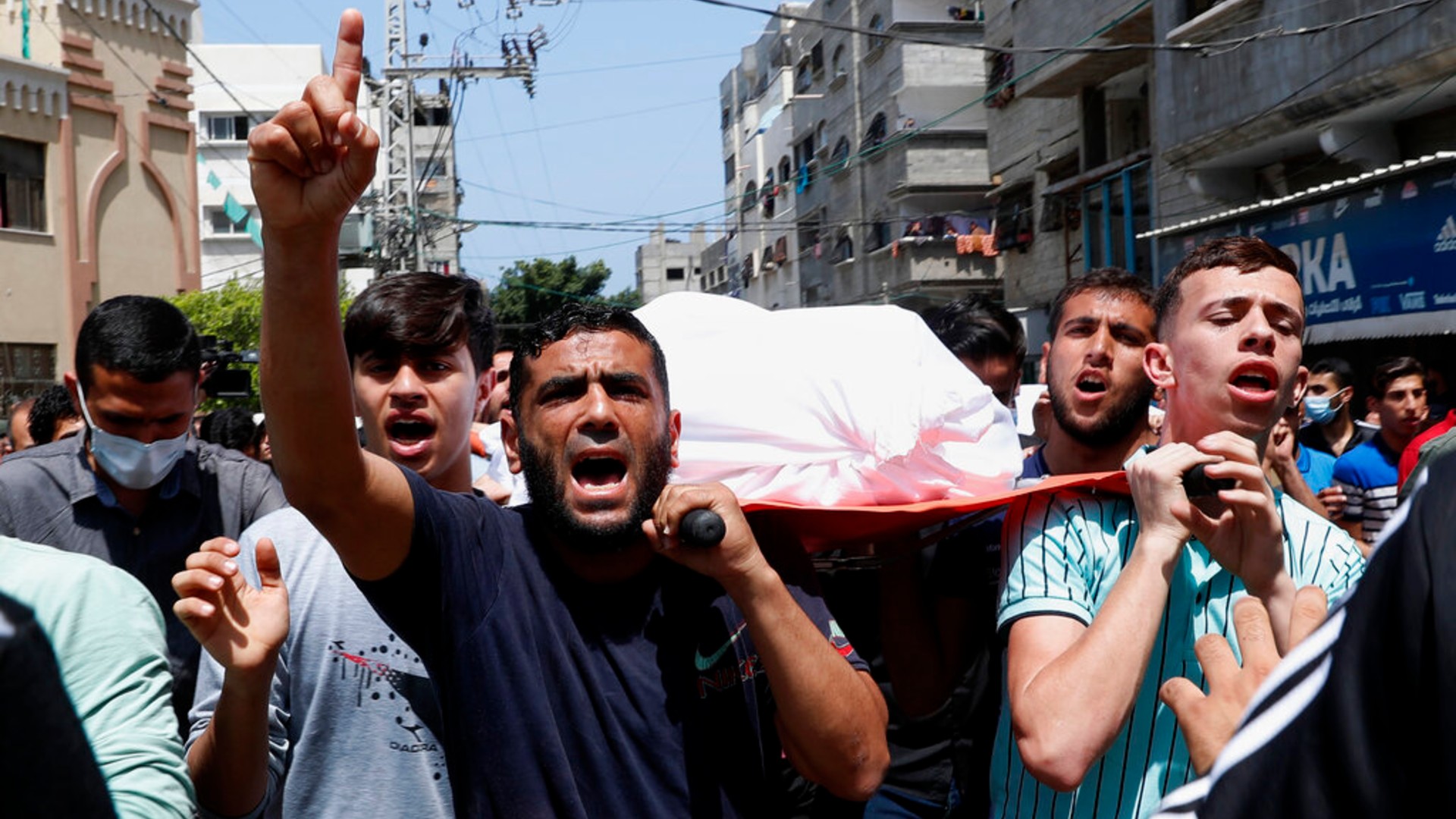 Mourners chant Islamic slogans while they carry the body of Amira Soboh, and her 19-year-old disabled son Abdelrahman, who were killed in Israeli airstrikes at their apartment building, during their funeral at the Shati refugee camp, in Gaza City, Tuesday, May 11, 2021. (AP Photo/Adel Hana)