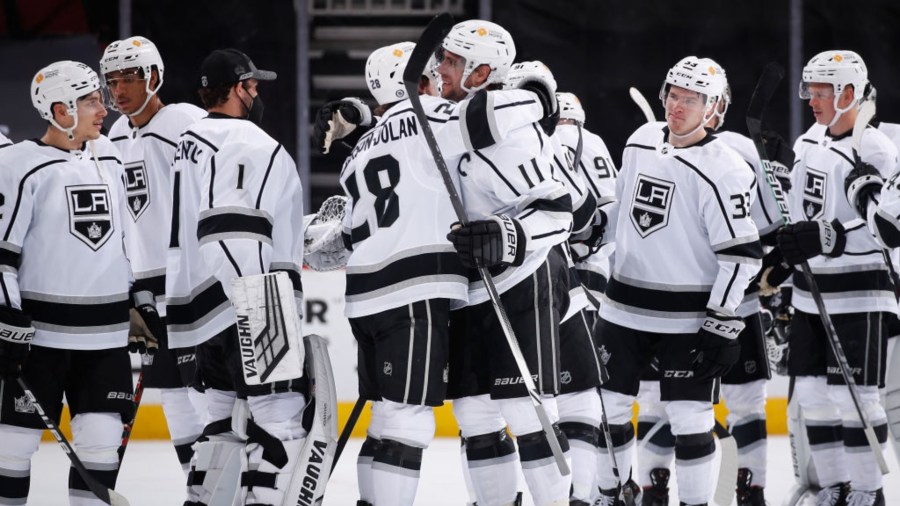 Anze Kopitar #11 of the Los Angeles Kings hugs Jaret Anderson-Dolan #28 after defeating the Arizona Coyotes and recording his 1,000th career point in the NHL game against the Arizona Coyotes at Gila River Arena on May 05, 2021 in Glendale, Arizona. (Christian Petersen/Getty Images)