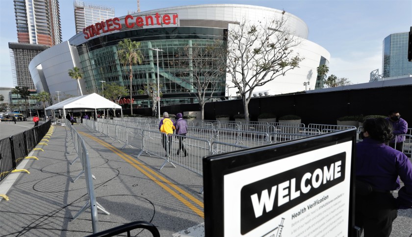 A slow trickle of fans head toward the Staples Center entrance for the Lakers-Celtics game on April 15, 2021. The Lakers are extending their lease with the arena. (Myung Chun / Los Angeles Times)