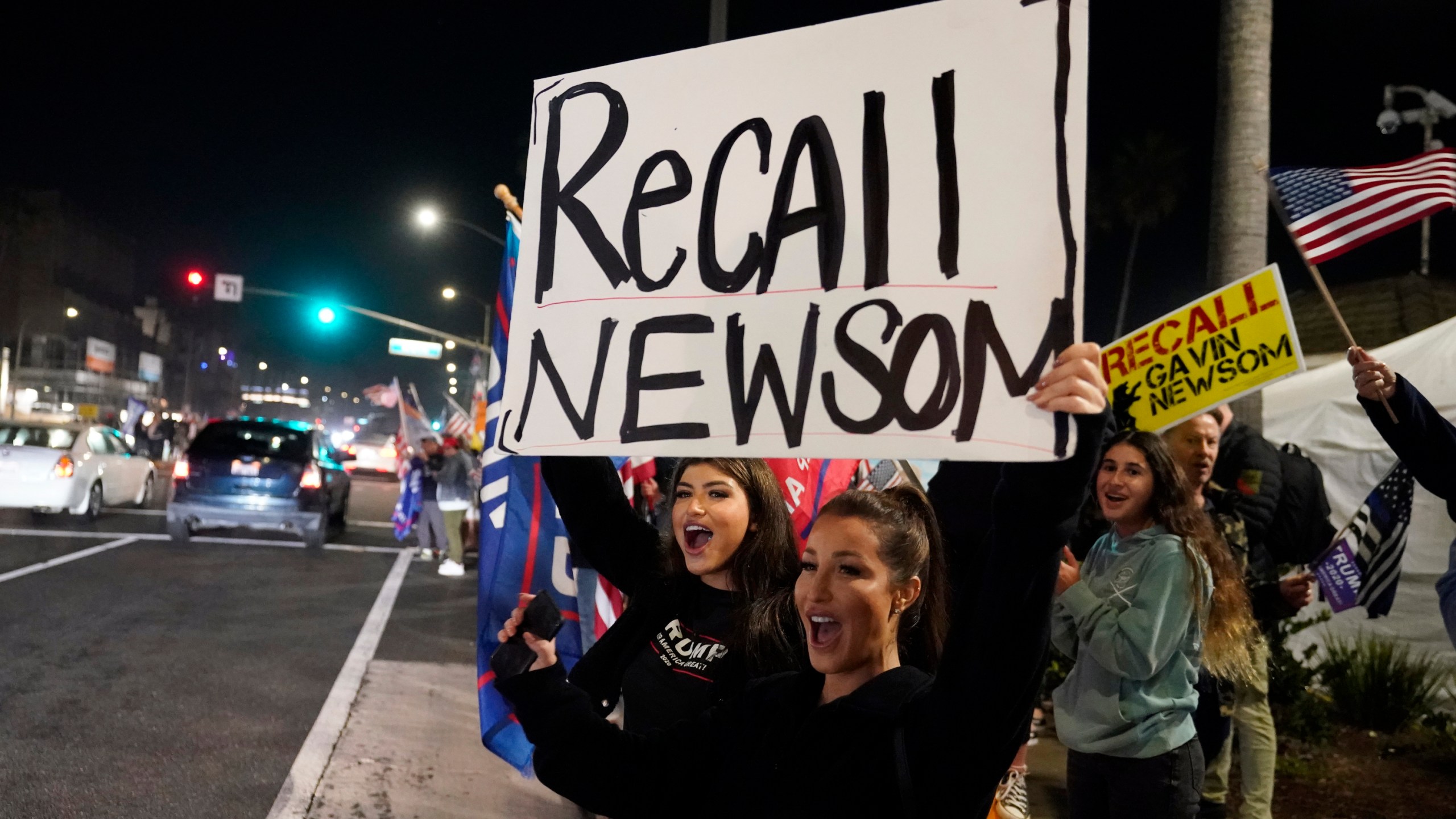 In this Saturday, Nov. 21, 2020, file photo, demonstrators shout slogans while carrying a sign calling for a recall on Gov. Gavin Newsom during a protest against a stay-at-home order amid the COVID-19 pandemic in Huntington Beach. (AP Photo/Marcio Jose Sanchez, File)