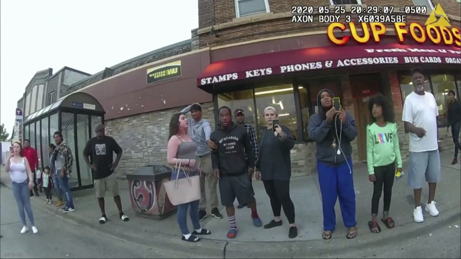 This May 25, 2020, file image from a police body camera shows bystanders including Alyssa Funari, left filming, Charles McMillan, center left in light colored shorts, Christopher Martin center in gray, Donald Williams, center in black, Genevieve Hansen, fourth from right filming, Darnella Frazier, third from right filming, as former Minneapolis police officer Derek Chauvin was recorded pressing his knee on George Floyd's neck for several minutes in Minneapolis.(Minneapolis Police Department via Associated Press)