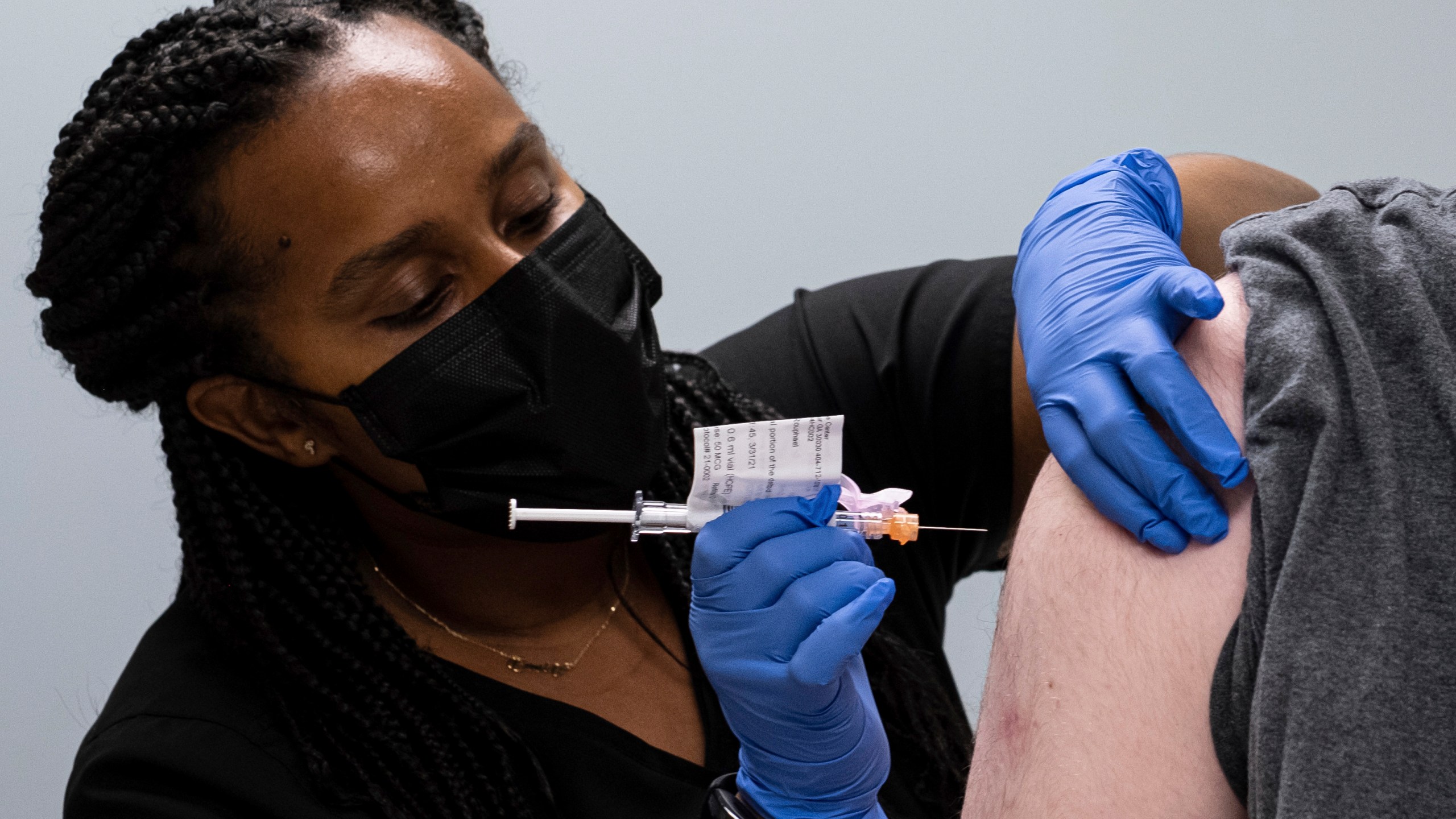 In this Wednesday, March 31, 2021 file photo, Cole Smith receives a Moderna variant vaccine shot from clinical research nurse Tigisty Girmay at Emory University's Hope Clinic in Decatur, Ga. As of June 2021, scientists have found clues that the world’s leading COVID-19 vaccines offer lasting protection that could diminish the need for frequent booster shots, but they caution that more research is needed and that virus mutations are still a wild card. (AP Photo/Ben Gray, File)