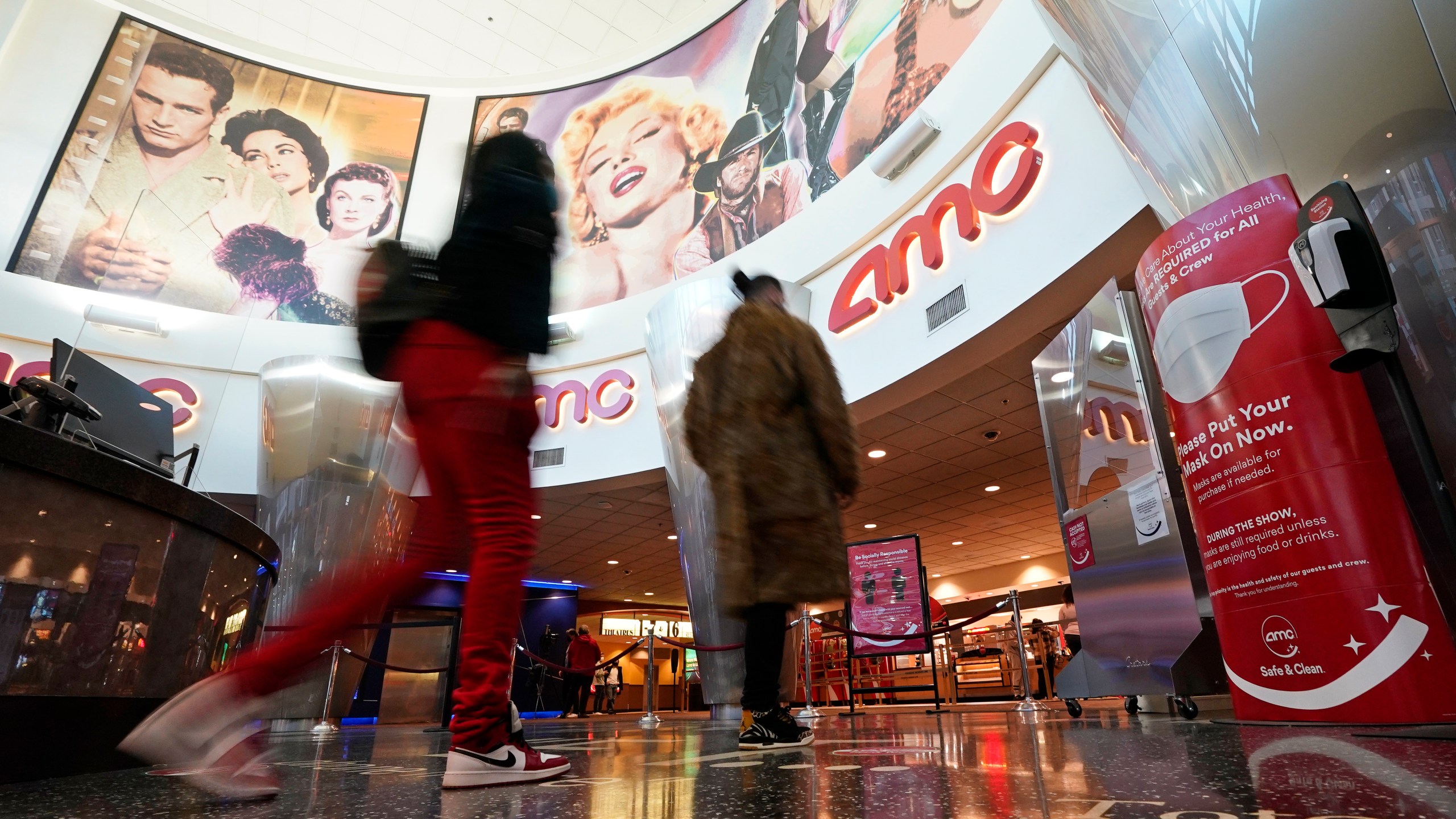 In this March 15, 2021, file photo movie patrons arrive to see a film at the AMC 16 theater in Burbank, Calif. AMC is looking to sell up to 11.5 million of its shares, as the movie theater operator looks to capitalize on its meme stock popularity. The announcement in a regulatory filing on Thursday, June 3 comes just two days after the company said it was raising $230.5 million through an 8.5 million share sale. (AP Photo/Mark J. Terrill, File)