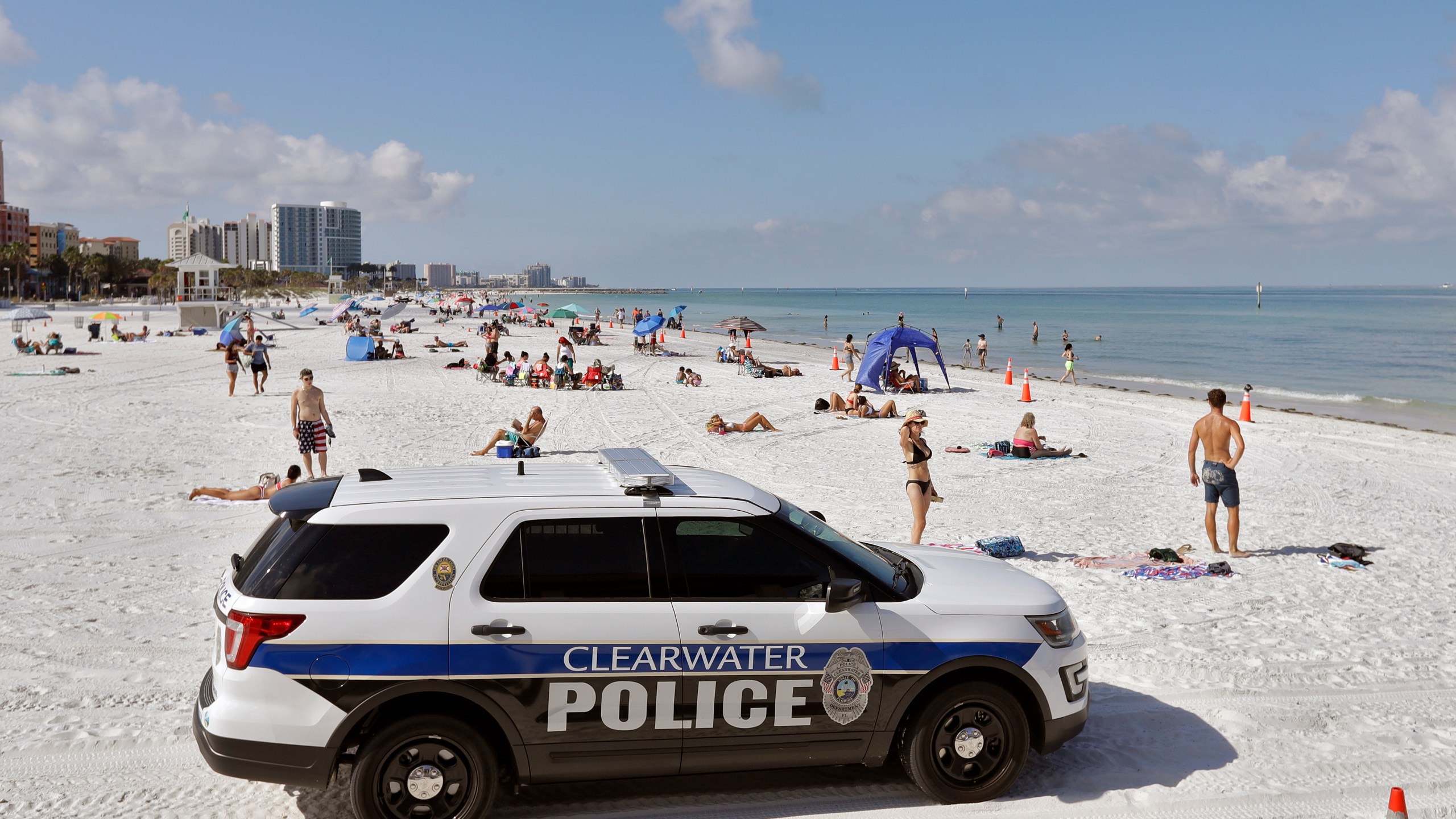 In this Monday, May 4, 2020 file photo, police officers patrol the area after Clearwater Beach officially reopened to the public in Clearwater Beach, Fla. (AP Photo/Chris O'Meara, File)