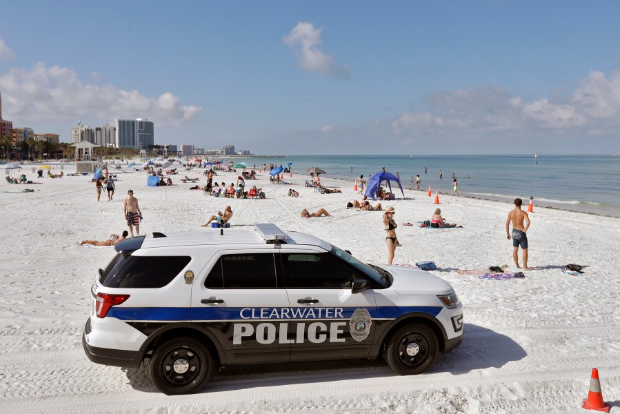 In this Monday, May 4, 2020 file photo, police officers patrol the area after Clearwater Beach officially reopened to the public in Clearwater Beach, Fla. (AP Photo/Chris O'Meara, File)