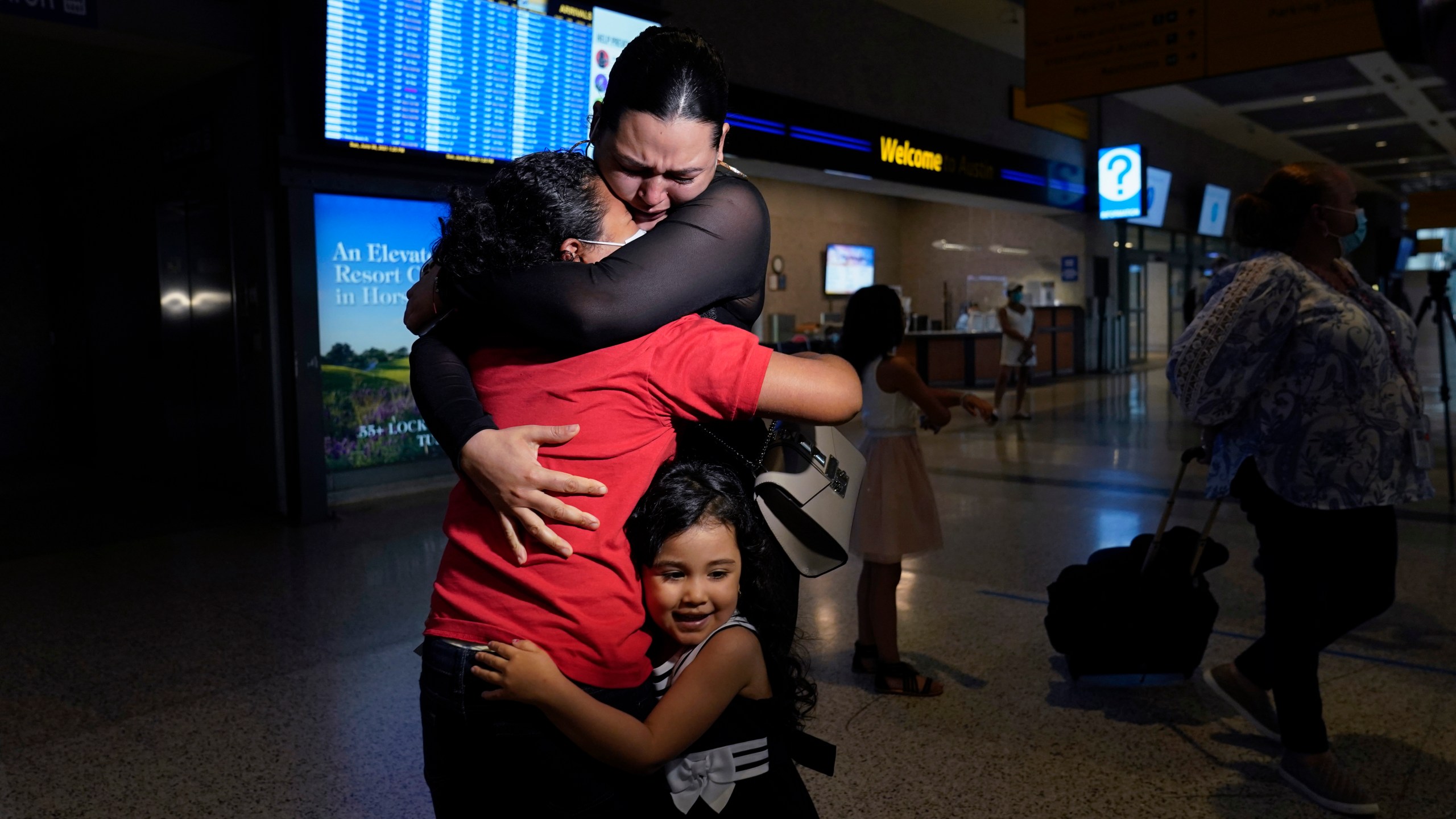 Emely, left, is reunited with her mother, Glenda Valdez and sister, Zuri, at Austin-Bergstrom International Airport, Sunday, June 6, 2021, in Austin, Texas. It had been six years since Valdez said goodbye to her daughter Emely in Honduras. Then, last month, she caught a glimpse of a televised Associated Press photo of a little girl in a red hoodie and knew that Emely had made the trip alone into the United States. On Sunday, the child was returned to her mother’s custody. (AP Photo/Eric Gay)