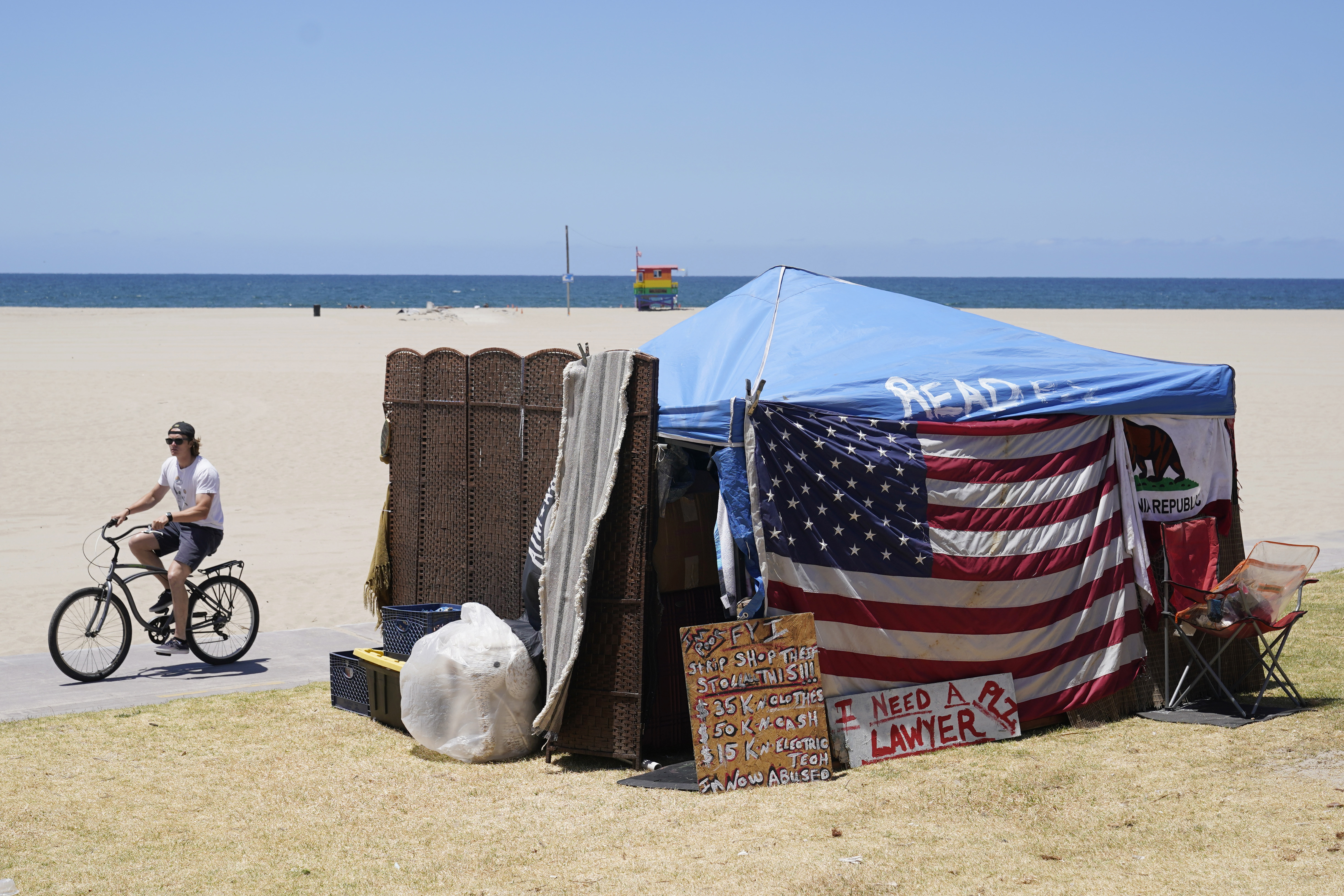 A U.S. flag is placed outside a tent in a homeless encampment Tuesday, June 8, 2021, in the Venice Beach section of Los Angeles. (AP Photo/Marcio Jose Sanchez)