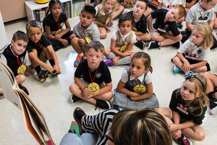 In this Aug. 22, 2018, file photo, students from two kindergarten classes at the Lewiston elementary campus of Saint Dominic Academy, listen to a teacher read a book, in Lewiston, Maine. (Russ Dillingham/Sun Journal via AP, File)