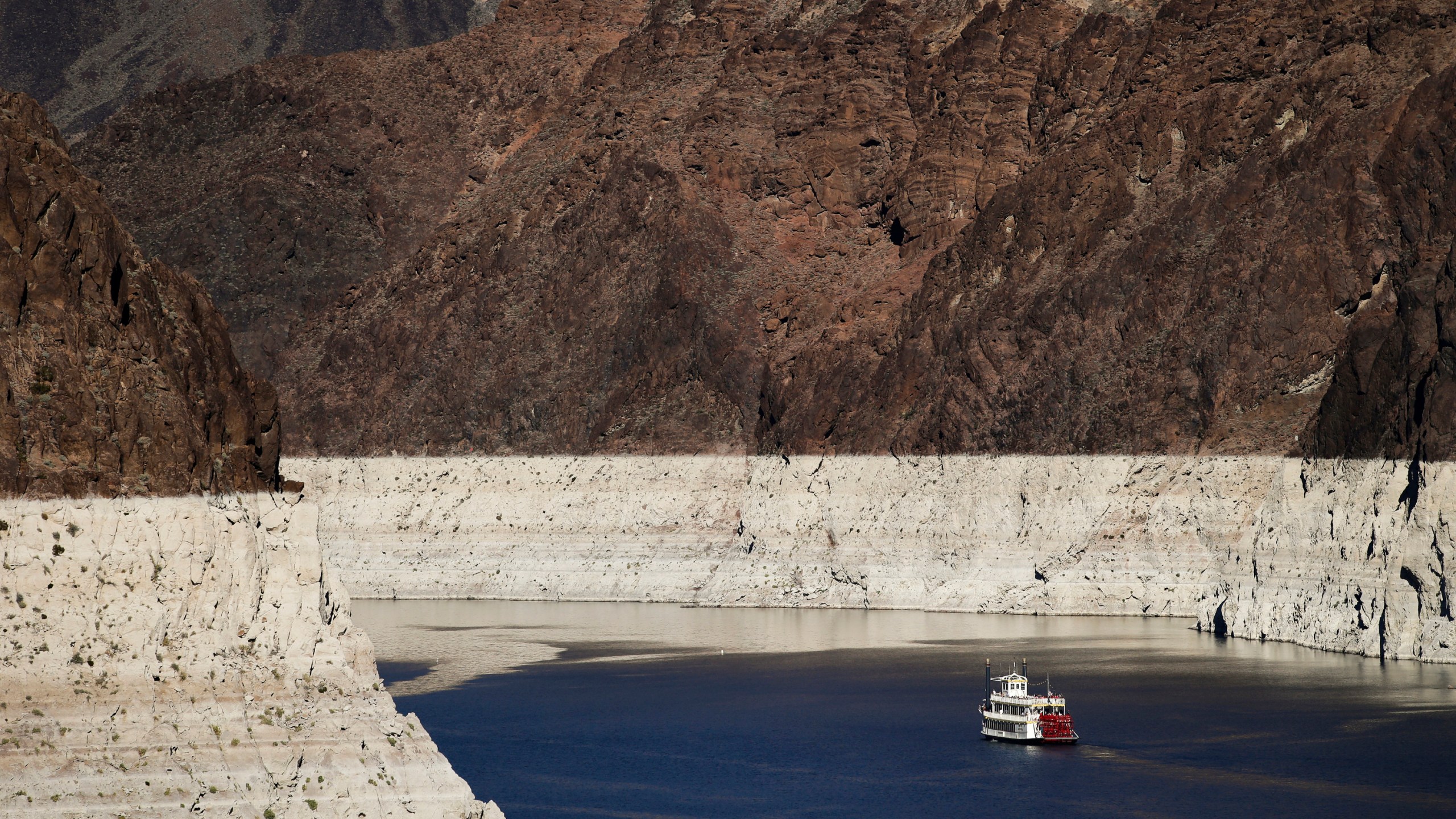 In this Oct. 14, 2015, file photo, a riverboat glides through Lake Mead on the Colorado River at Hoover Dam near Boulder City, Nev. The key reservoir on the Colorado River is expected to match its record low level on Thursday, June 10, 2021. The dropping surface elevation of Lake Mead along the Arizona-Nevada border is the another sign of the drought's grip on the region. (AP Photo/Jae C. Hong, File)