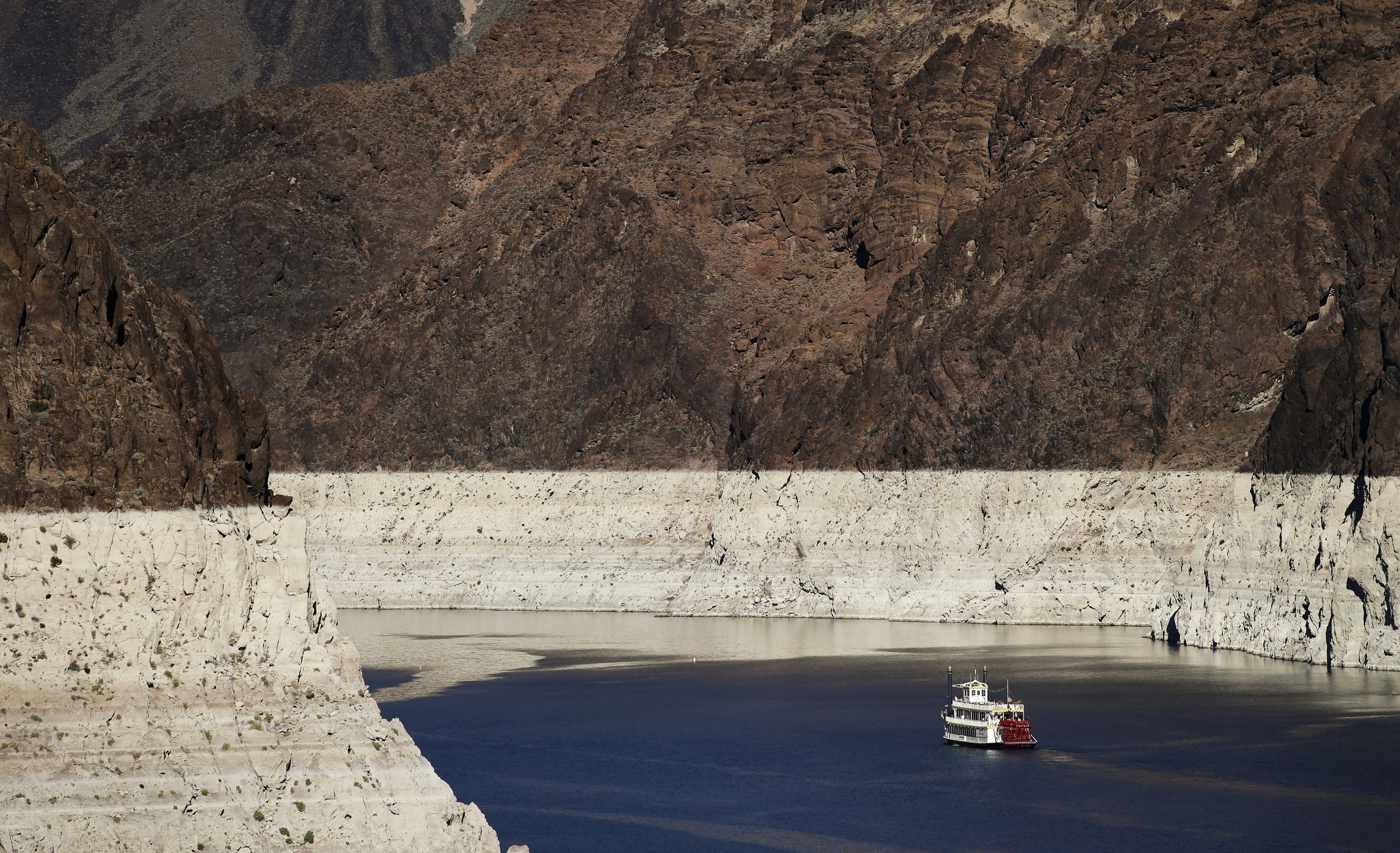 In this Oct. 14, 2015, file photo, a riverboat glides through Lake Mead on the Colorado River at Hoover Dam near Boulder City, Nev. The key reservoir on the Colorado River is expected to match its record low level on Thursday, June 10, 2021. The dropping surface elevation of Lake Mead along the Arizona-Nevada border is the another sign of the drought's grip on the region. (AP Photo/Jae C. Hong, File)