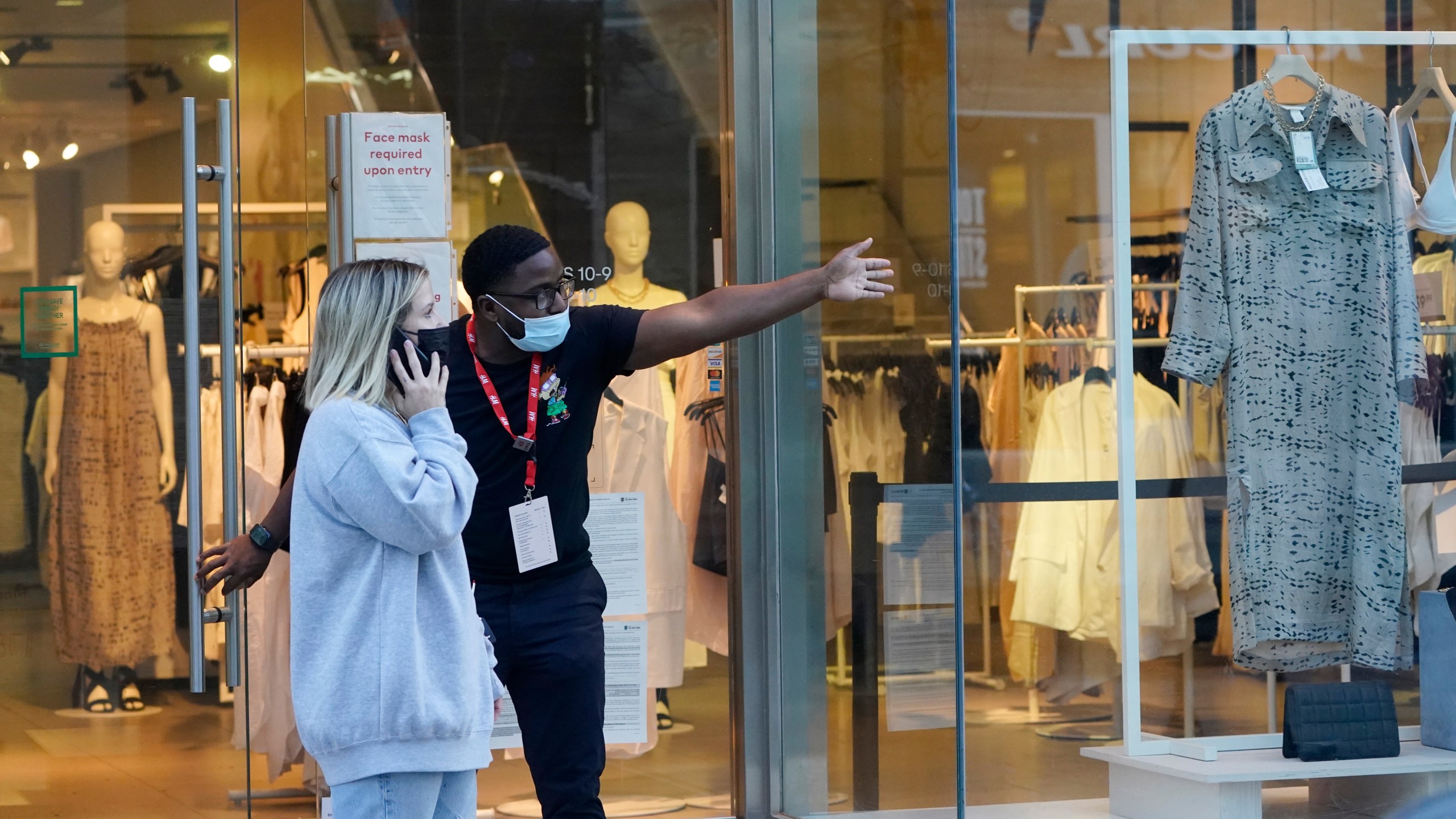 A salesperson gives directions to a shopper amid the COVID-19 pandemic on The Promenade Wednesday, June 9, 2021, in Santa Monica, Calif. (AP Photo/Marcio Jose Sanchez)