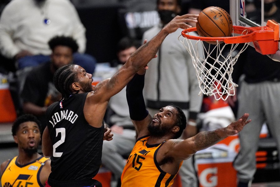 Los Angeles Clippers forward Kawhi Leonard, center, dunks over Utah Jazz center Derrick Favors, right, as guard Donovan Mitchell watches during the first half in Game 4 of a second-round NBA basketball playoff series on June 14, 2021, in Los Angeles. (Mark J. Terrill / Associated Press)