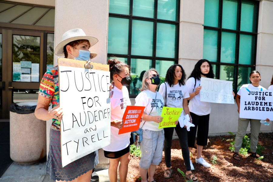 Supporters of the late Laudemer Arboleda and the late Tyrell Wilson hold signs following an arraignment hearing for Danville police officer Andrew Hall outside the A.F. Bray Courthouse in Martinez, Calif., on June 16, 2021.(Yalonda M. James/San Francisco Chronicle via AP)