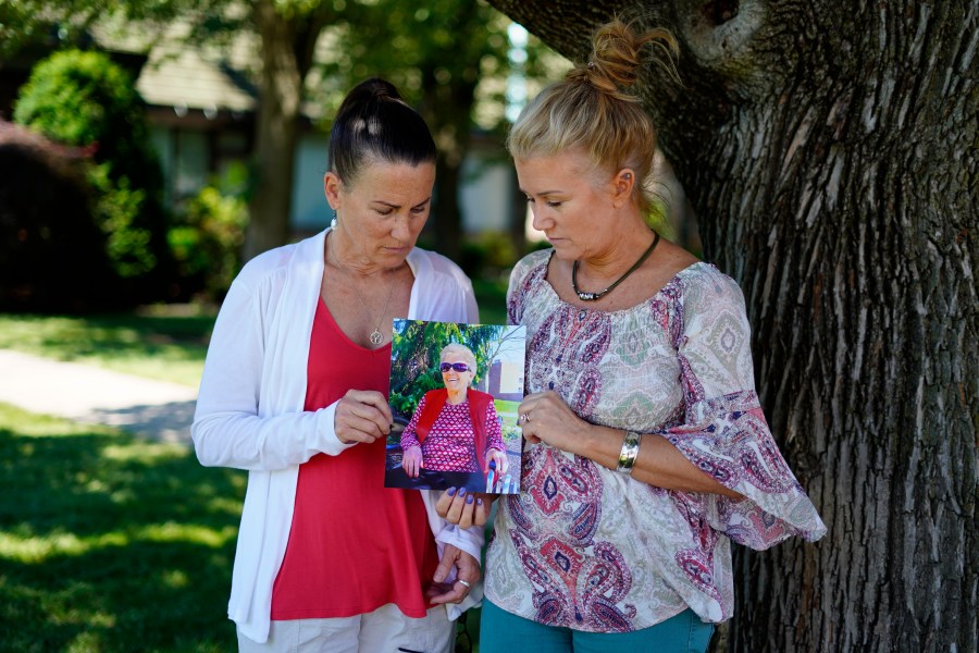 Angela Ermold, right, and her sister, Denise Gracely, hold a photo of their mother, Marian Rauenzahn, Thursday, June 17, 2021, in Fleetwood, Pa. (AP Photo/Matt Slocum)