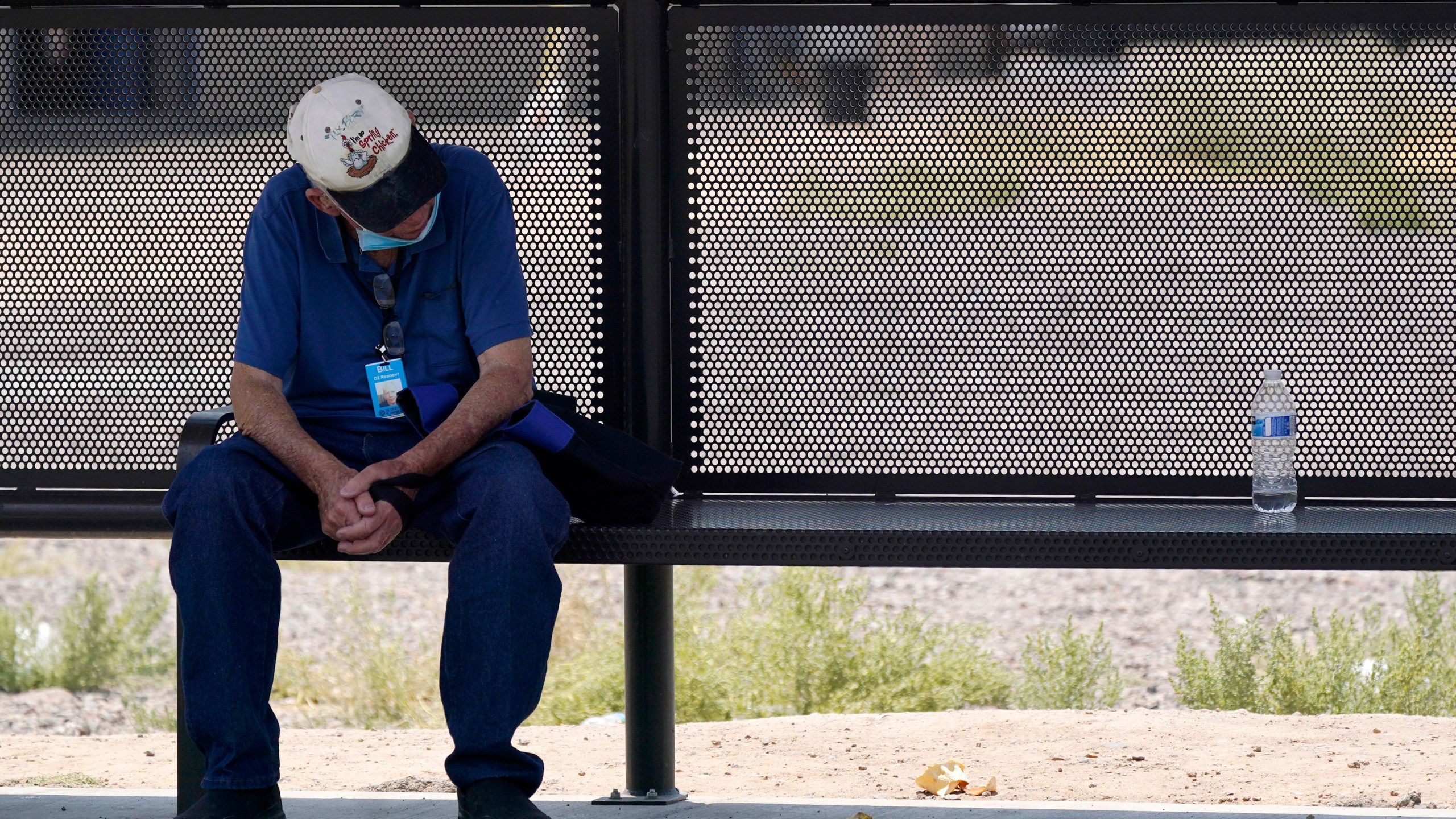 A person waits for a bus in the shade as the heat wave in the Western states continues on June 17, 2021, in Phoenix. (AP Photo/Ross D. Franklin)