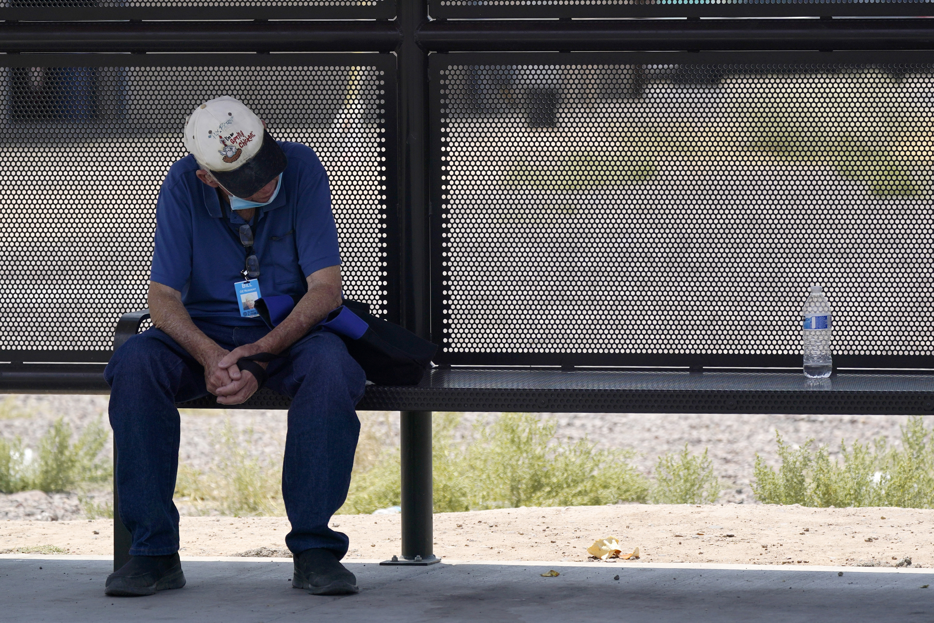 A person waits for a bus in the shade as the heat wave in the Western states continues on June 17, 2021, in Phoenix. (AP Photo/Ross D. Franklin)