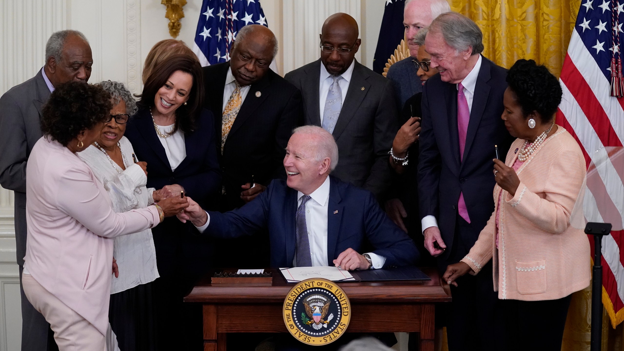 In this June 17, 2021, file photo, President Joe Biden hands a pen to Rep. Barbara Lee, D-Calif., after signing the Juneteenth National Independence Day Act, in the East Room of the White House in Washington. From left, Rep. Barbara Lee, D-Calif, Rep. Danny Davis, D-Ill., Opal Lee, Sen. Tina Smith, D-Minn., obscured, Vice President Kamala Harris, House Majority Whip James Clyburn of S.C., Sen. Raphael Warnock, D-Ga., Sen. John Cornyn, R-Texas, Rep. Joyce Beatty, D-Ohio, obscured, Sen. Ed Markey, D-Mass., and Rep. Sheila Jackson Lee, D-Texas. (AP Photo/Evan Vucci, File)