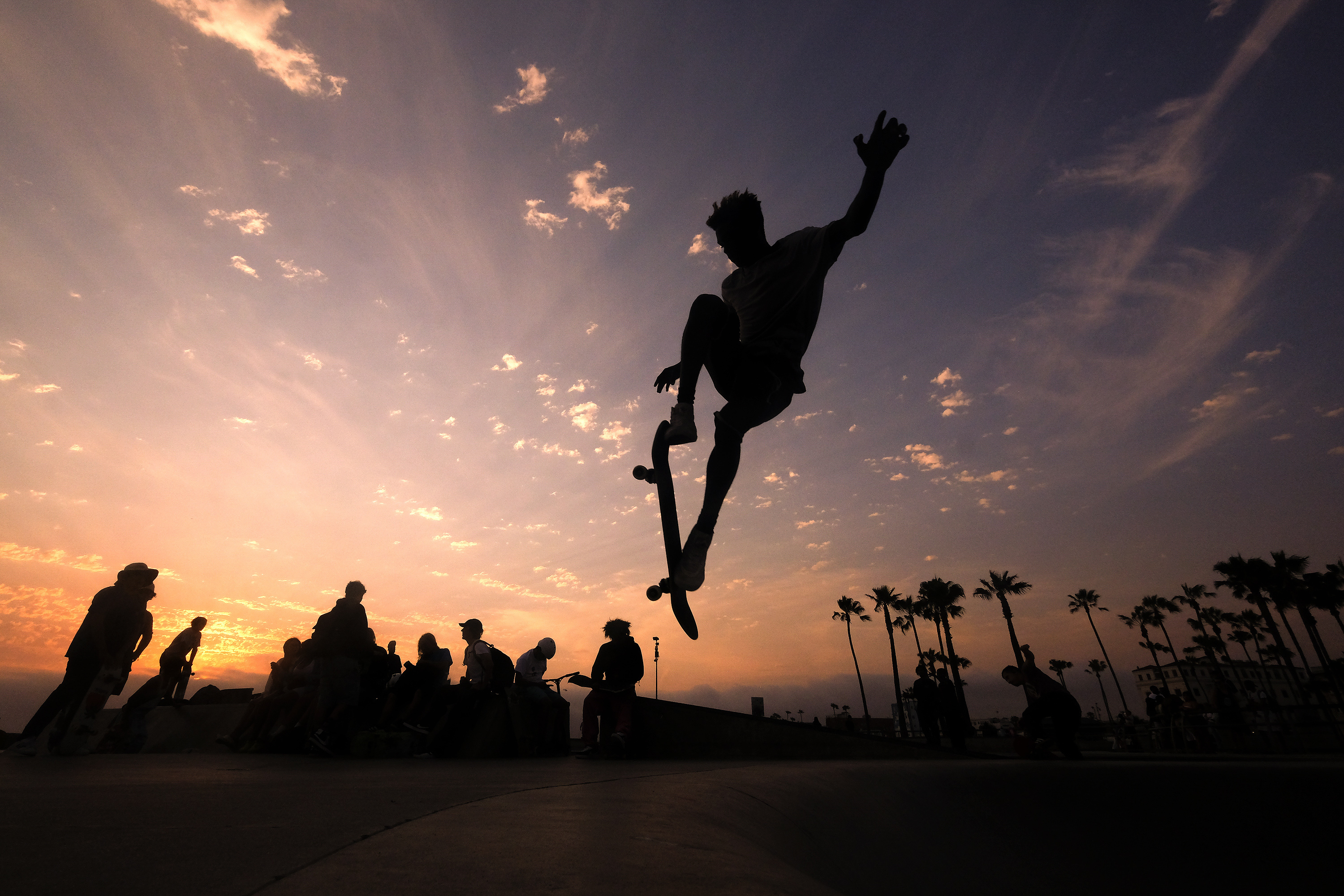 In this Wednesday, June 16, 2021, file photo, a skateboarder is silhouetted as he jumps high at the skateboard park during sunset in the Venice Beach section of Los Angeles. The Southwest U.S. continued to bake Saturday, June 19, and weather forecasters kept warnings in effect for excessive heat in Arizona, Nevada and desert areas, at least through the weekend. (AP Photo/Ringo H.W. Chiu, File)