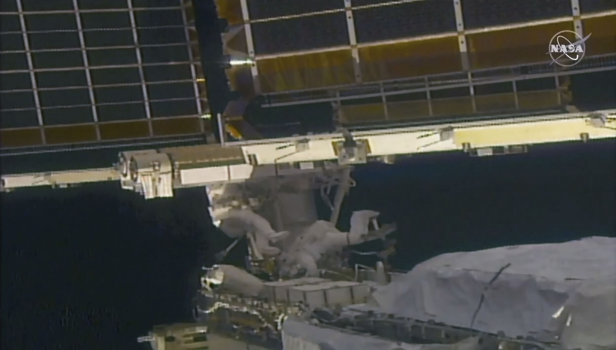 In this image taken from NASA video, NASA astronaut Shane Kimbrough, left, and French astronaut Thomas Pesquet work on the solar array outside the International Space Station, Sunday, June 20 2021. (NASA via AP)