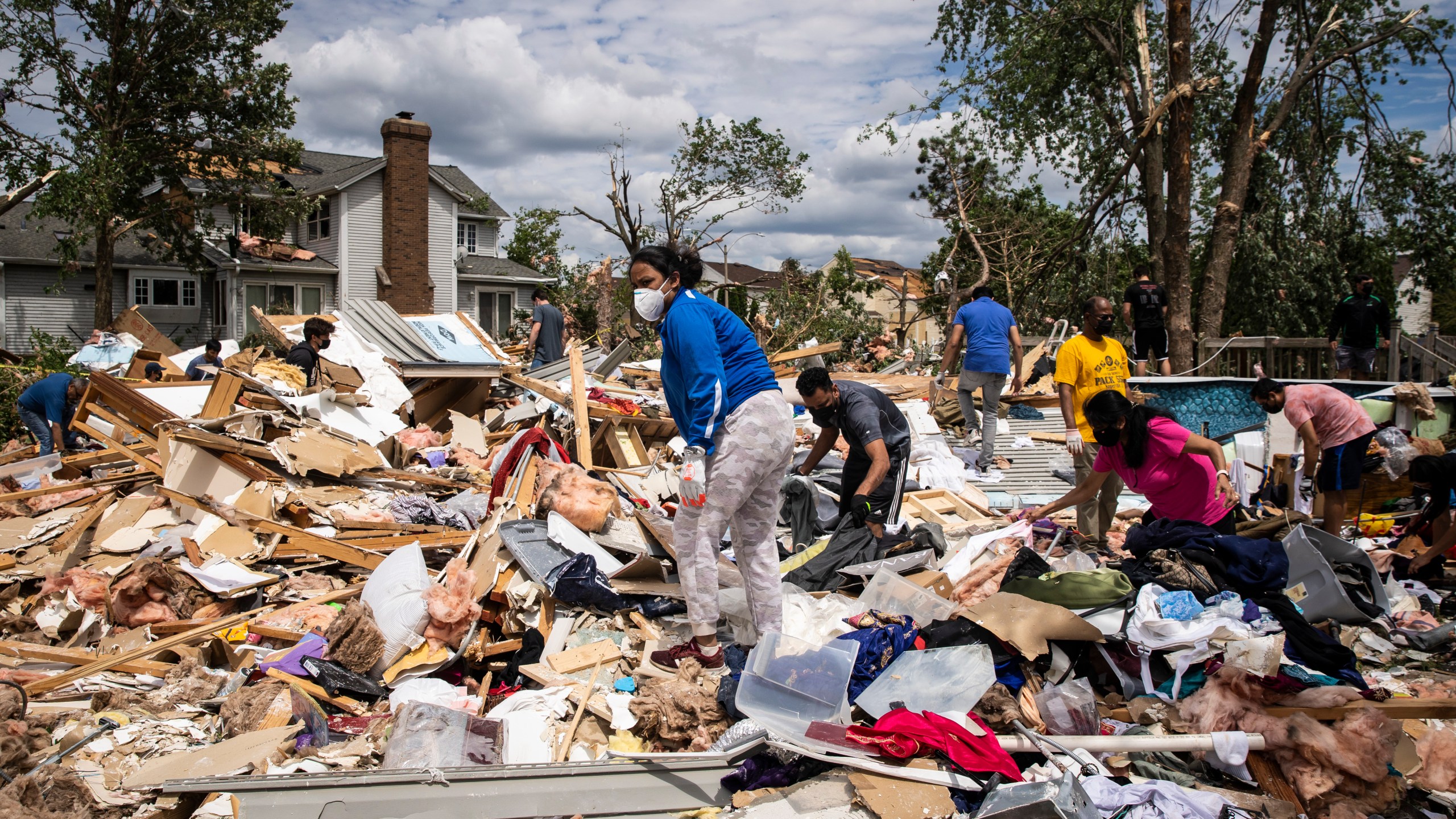 Dozens of volunteers help clean up a demolished home on Princeton Circle near Ranchview Drive in Naperville after a tornado ripped through the western suburbs overnight, Monday afternoon, June 21, 2021. (Ashlee Rezin Garcia/Sun-Times/Chicago Sun-Times via AP)