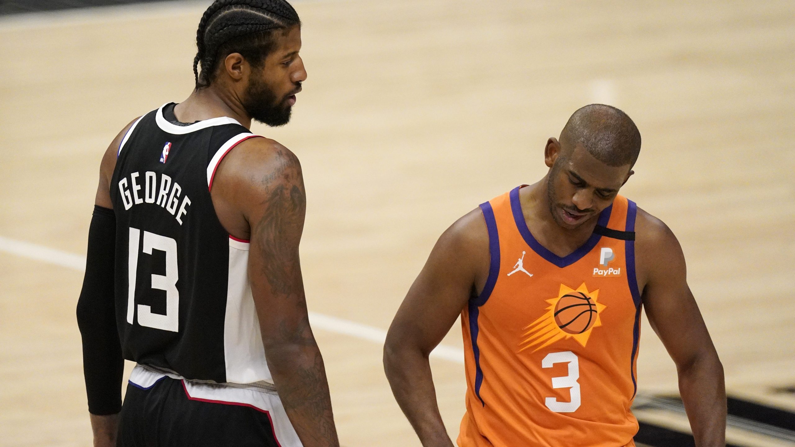 Los Angeles Clippers guard Paul George, left, tries to talk to Phoenix Suns guard Chris Paul during the second half in Game 3 of the NBA basketball Western Conference Finals in Los Angeles on June 24, 2021. (Mark J. Terrill / Associated Press)