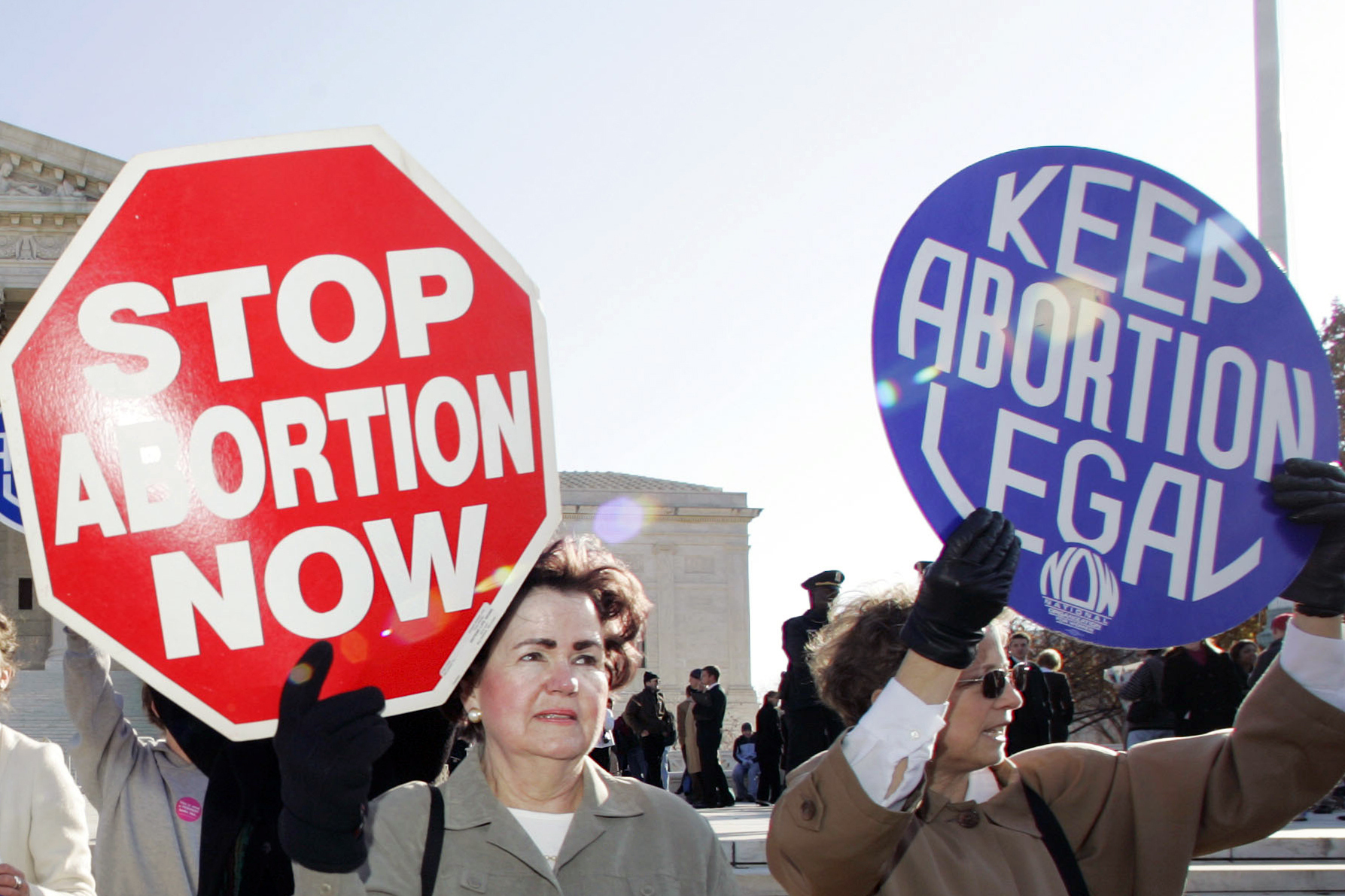 In this Nov. 30, 2005 file photo, an anti-abortion supporter stands next to a pro-choice demonstrator outside the U.S. Supreme Court in Washington. The new poll from The Associated Press-NORC Center for Public Affairs Research finds 61% of Americans say abortion should be legal in most or all circumstances in the first trimester of a pregnancy. However, 65% said abortion should usually be illegal in the second trimester, and 80% said that about the third trimester. (AP Photo/Manuel Balce Ceneta)