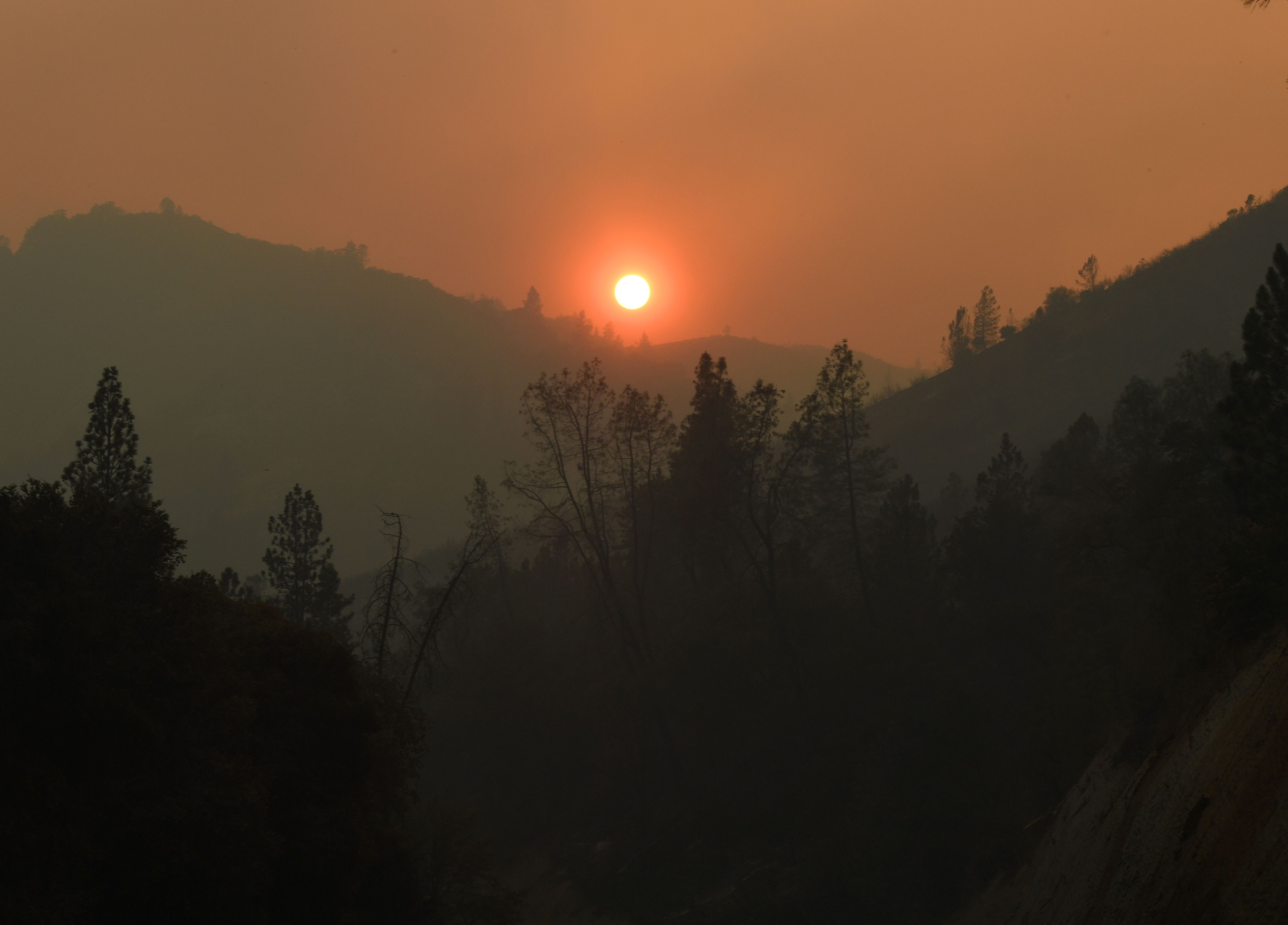 The sun sets over an area partially burnt by the Carr fire as it spreads towards the town of Lewiston near Redding, California, on Auigust 2, 2018. (Mark Ralston/AFP via Getty Images)