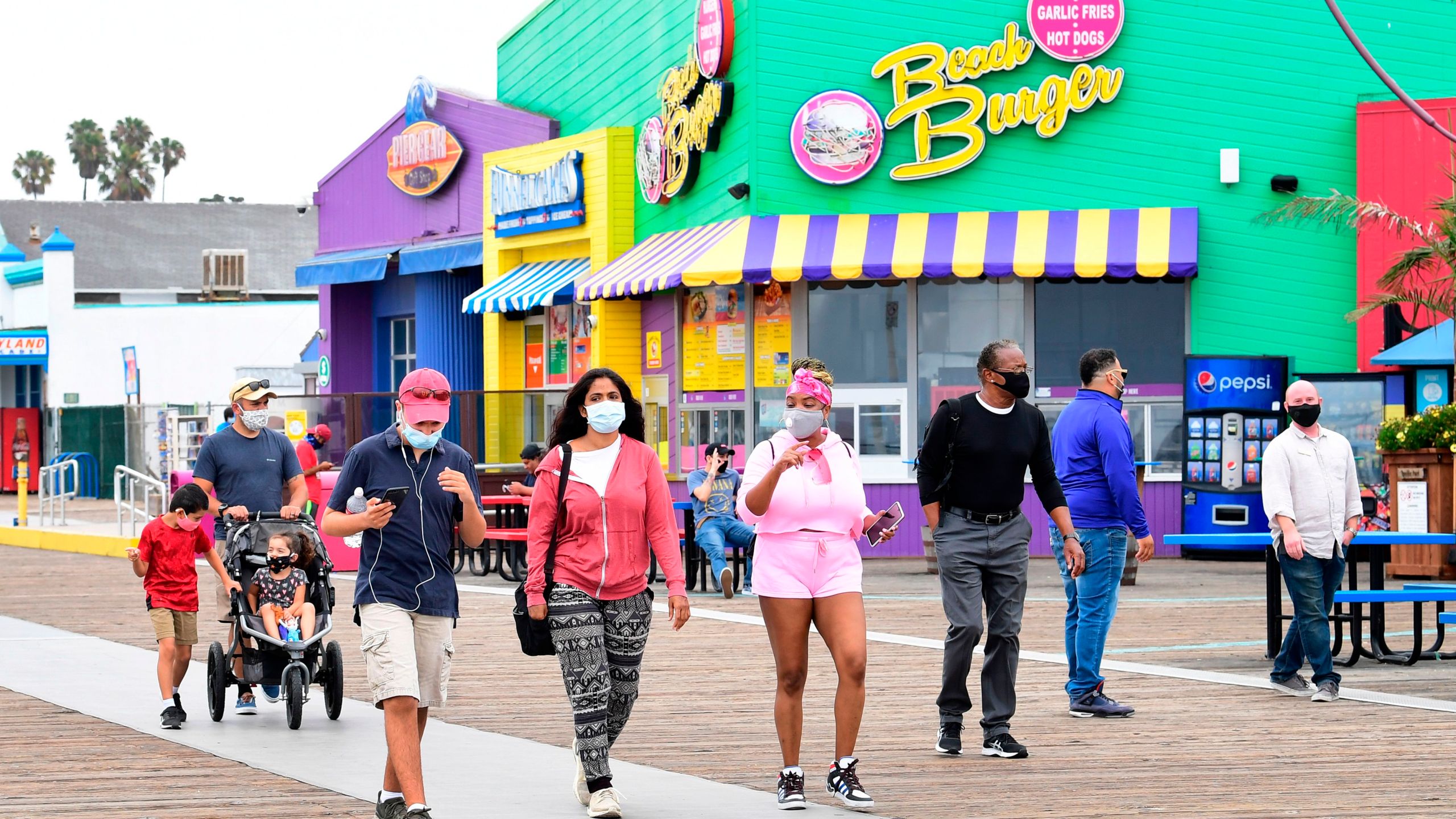 People wearing face masks at Santa Monica Pier on June 26, 2020 in Santa Monica. ( FREDERIC J. BROWN/AFP via Getty Images)