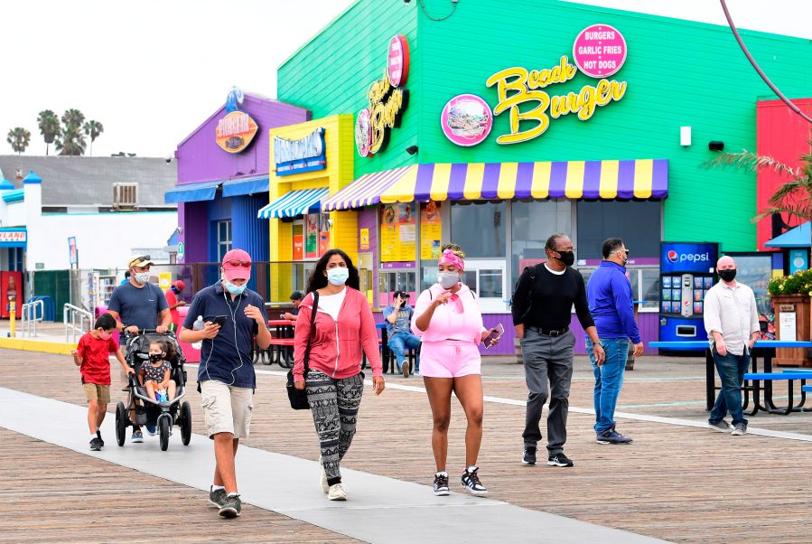 People wearing face masks at Santa Monica Pier on June 26, 2020 in Santa Monica. ( FREDERIC J. BROWN/AFP via Getty Images)