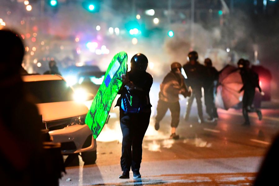 People run from tear gas and rubber bullets fired by Los Angeles County sheriff's deputies dispersing a crowd of demonstrators gathered to protest again in the wake of Dijon Kizzee's killing, outside the South LA sheriff's station on September 8, 2020 in Los Angeles, California. (Frederic J. Brown/AFP via Getty Images)