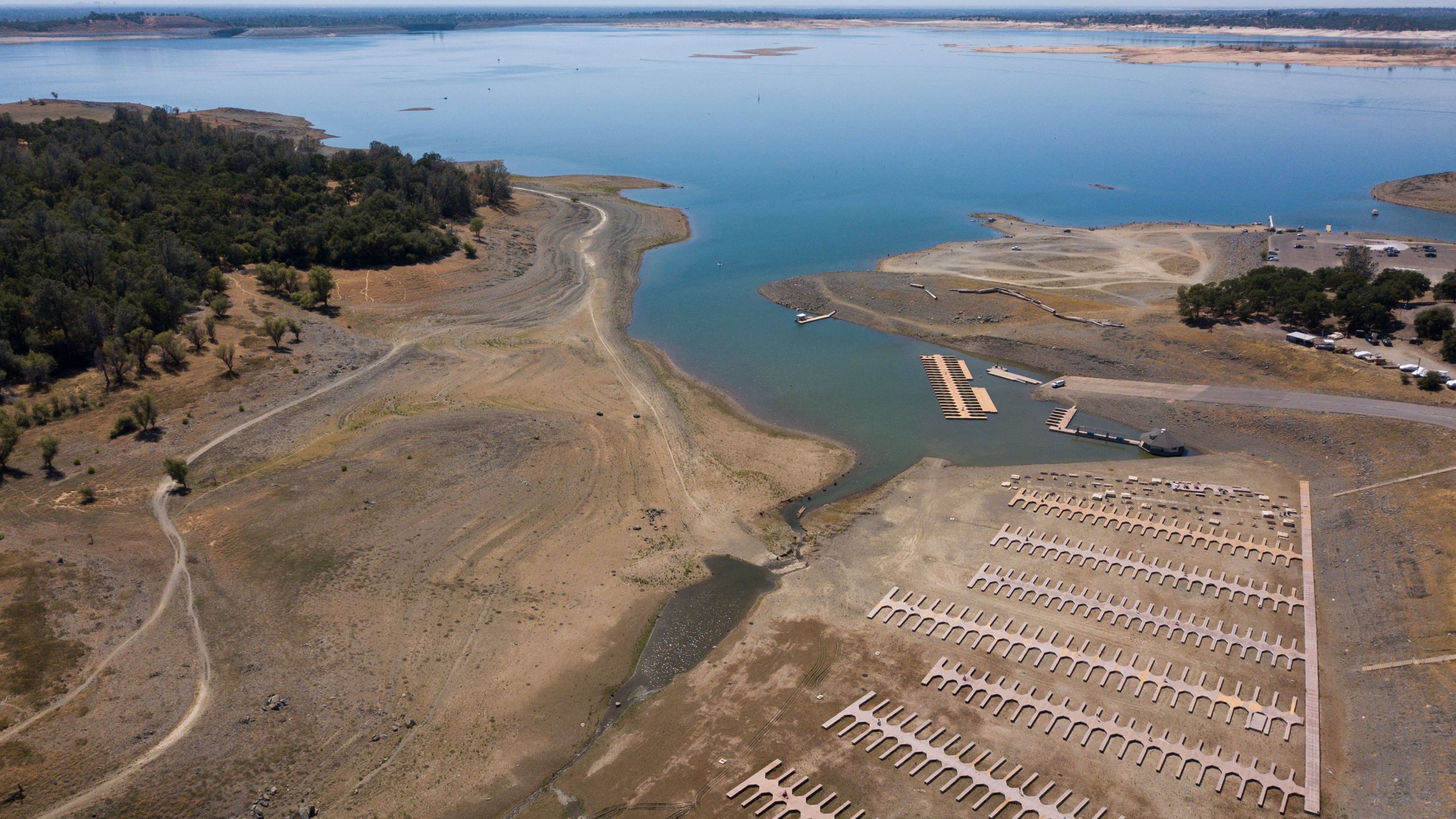 This aerial image shows empty boat slips sitting on a dry lake bed at Folsom Lake Marina as the lake experiences lower water levels during the California drought emergency on May 27, 2021 in El Dorado Hills. ( PATRICK T. FALLON/AFP via Getty Images)