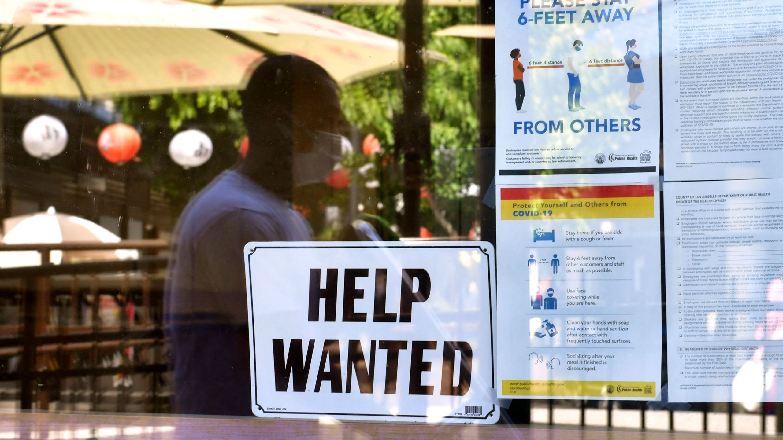 A "Help Wanted" sign is posted beside coronavirus safety guidelines in front of a restaurant in Los Angeles, California on May 28, 2021. (FREDERIC J. BROWN/AFP via Getty Images)