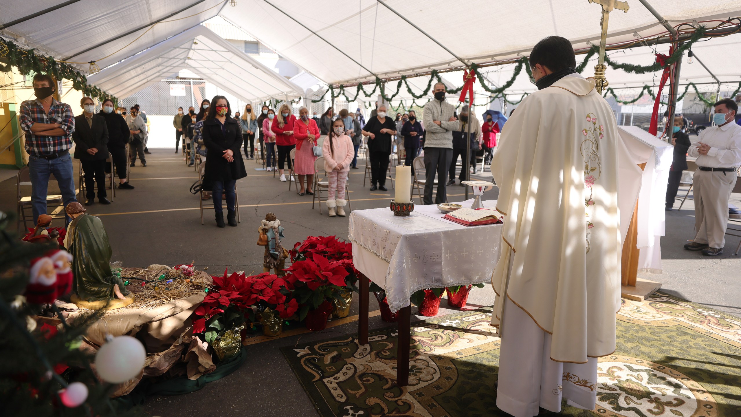 Father Rafael Saiz celebrates Christmas Mass outdoors at St. Mary's Catholic Church beneath a tent with social distancing due to the COVID-19 pandemic on December 25, 2020 in Los Angeles, California. (Mario Tama/Getty Images)