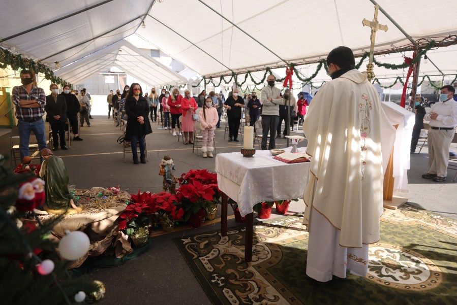 Father Rafael Saiz celebrates Christmas Mass outdoors at St. Mary's Catholic Church beneath a tent with social distancing due to the COVID-19 pandemic on December 25, 2020 in Los Angeles, California. (Mario Tama/Getty Images)