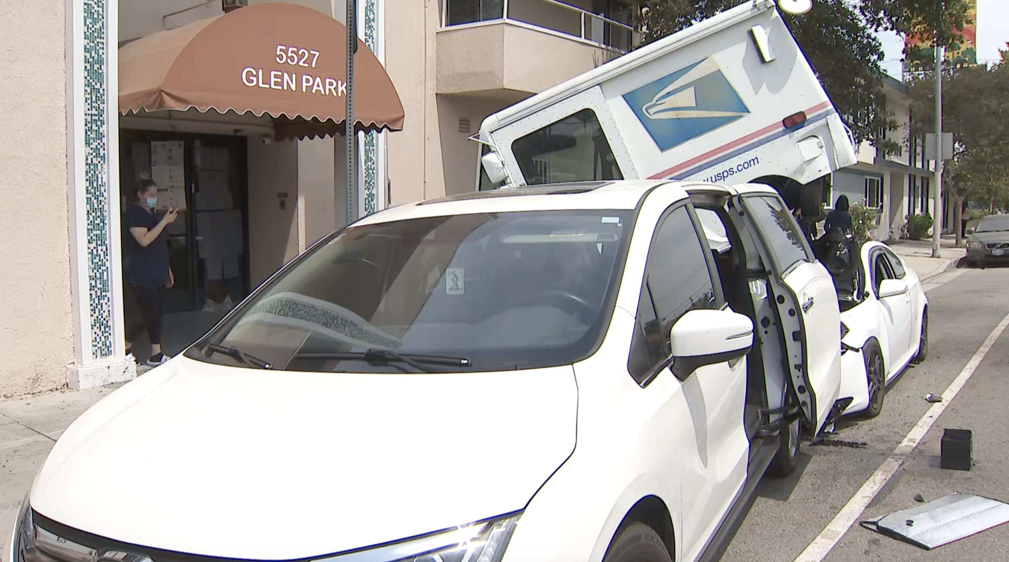 A mail truck sits atop a sedan after being rear-ended in Valley Village on June 29, 2021. (KTLA)