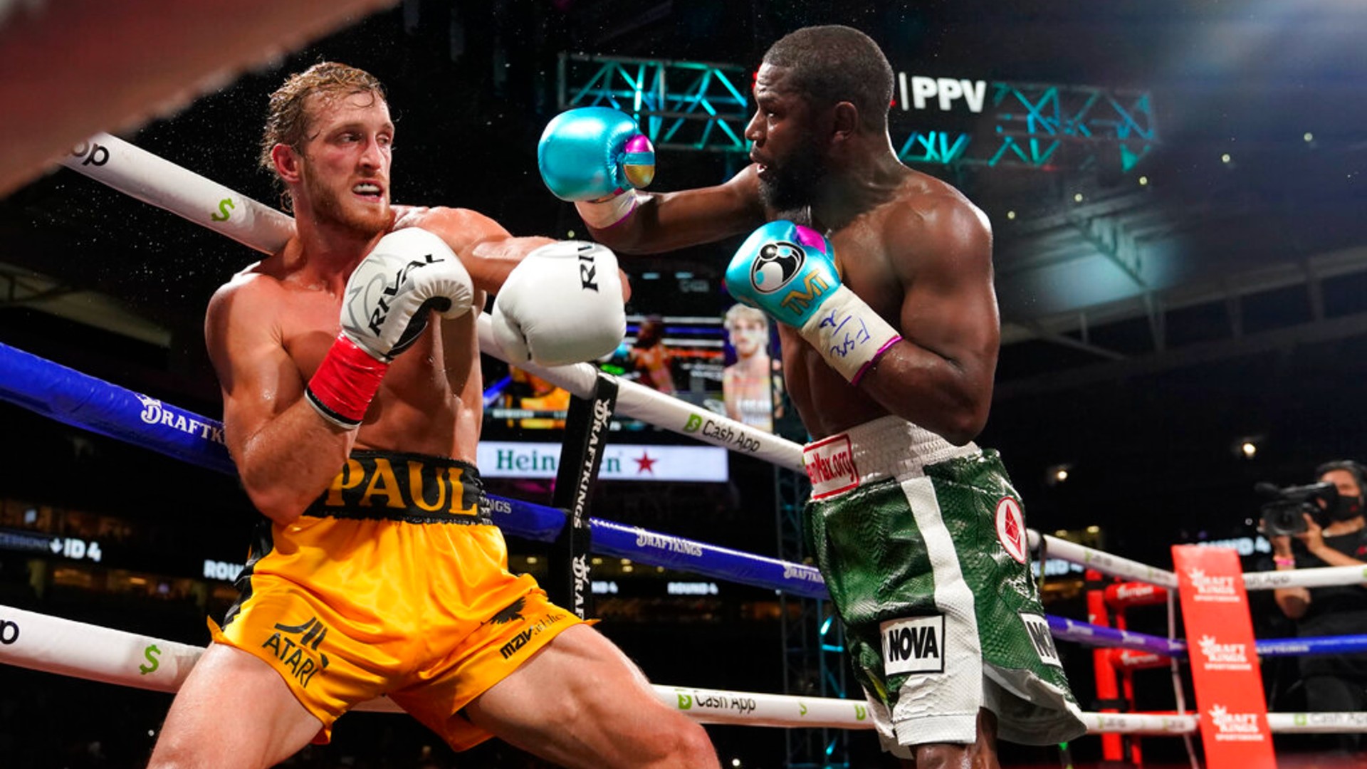 Floyd Mayweather, right, throws a punch at Logan Paul, left, during an exhibition boxing match at Hard Rock Stadium, Sunday, June 6, 2021, in Miami Gardens, Fla. (AP Photo/Lynne Sladky)