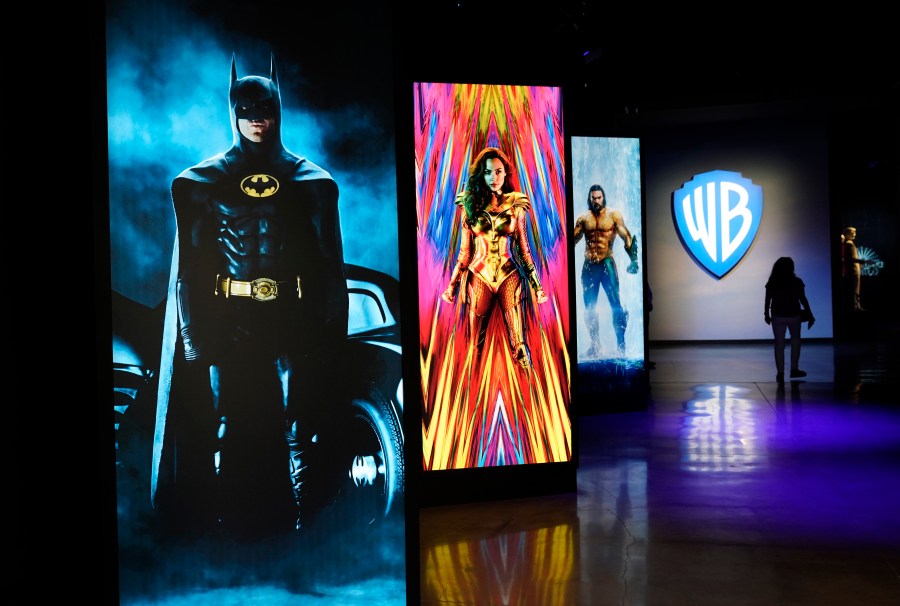 A visitor walks past portraits of DC Comics superheroes as she enters the "Action and Magic Made Here" interactive experience at the Warner Bros. Studio Tour Hollywood media preview on June 24, 2021, in Burbank, Calif. (AP Photo/Chris Pizzello)