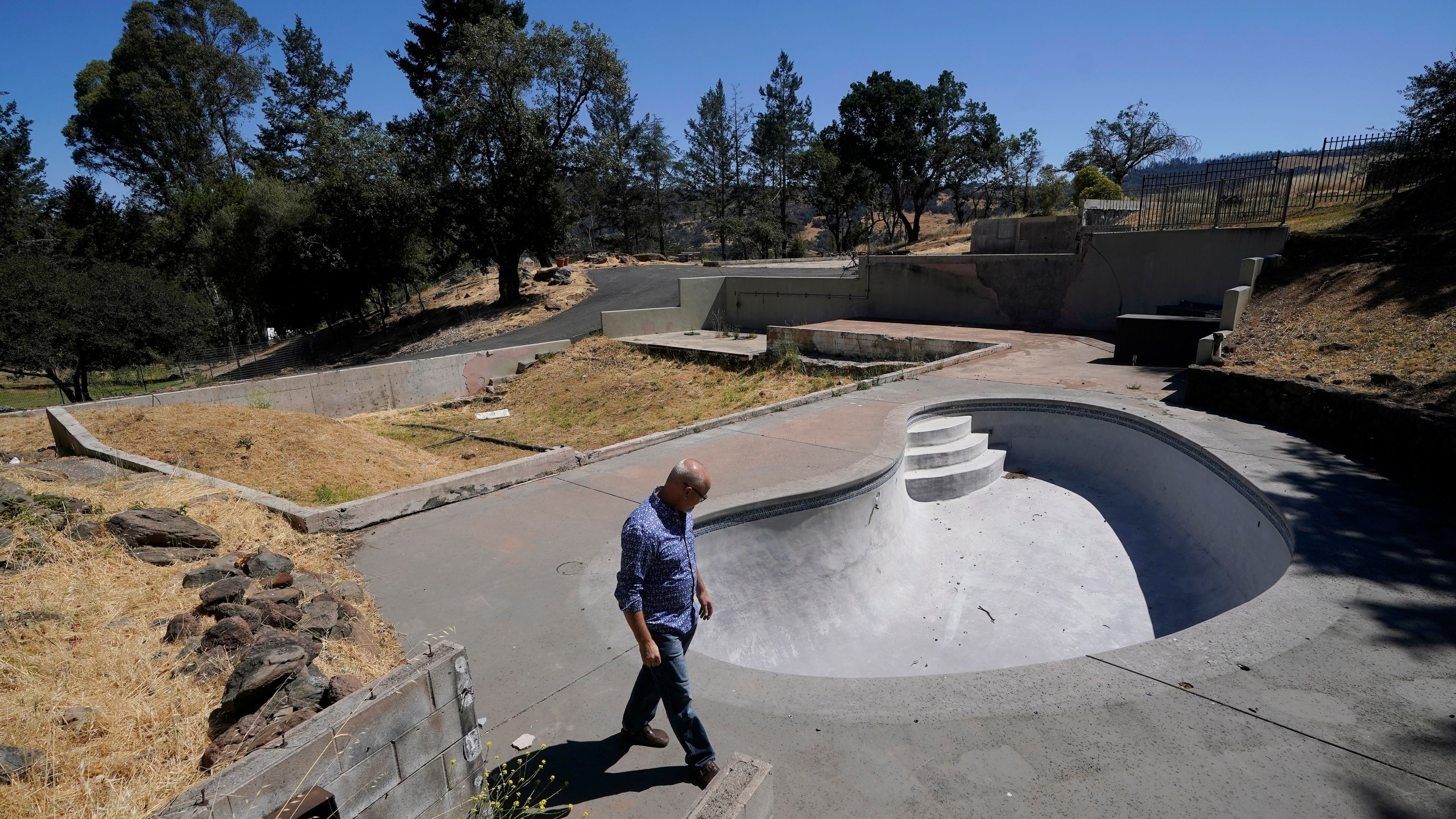 Will Abrams walks on the lot of his family home that was destroyed by wildfires in 2017 while interviewed in Santa Rosa, Calif., Thursday, June 24, 2021. “I have been really disappointed," Abrams said. “The bankruptcy was sold as something that was going to hold PG&E to account, and it was not. Bankruptcy is not a process to reorganize. It is a process to divide up the dollars." (AP Photo/Jeff Chiu)