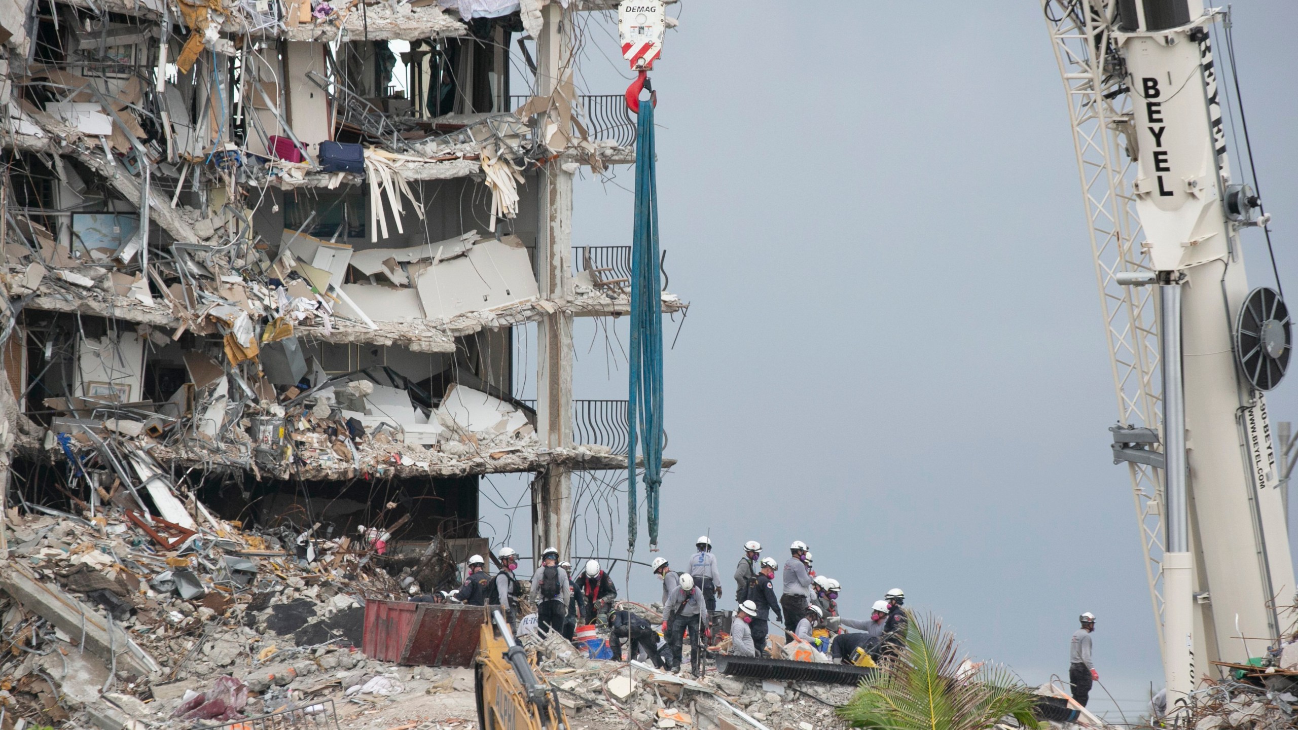 Rescue workers continue to search for survivors in the collapsed building of the Champlain Towers South, Wednesday June 30, 2021, in Surfside, Fla. Crews searching for survivors in the ruins of a collapsed Florida condo tower have built a ramp that should allow the use of heavier equipment, potentially accelerating the removal of concrete that “could lead to incredibly good news events,” the state fire marshal said Wednesday. (Emily Michot/Miami Herald via AP)