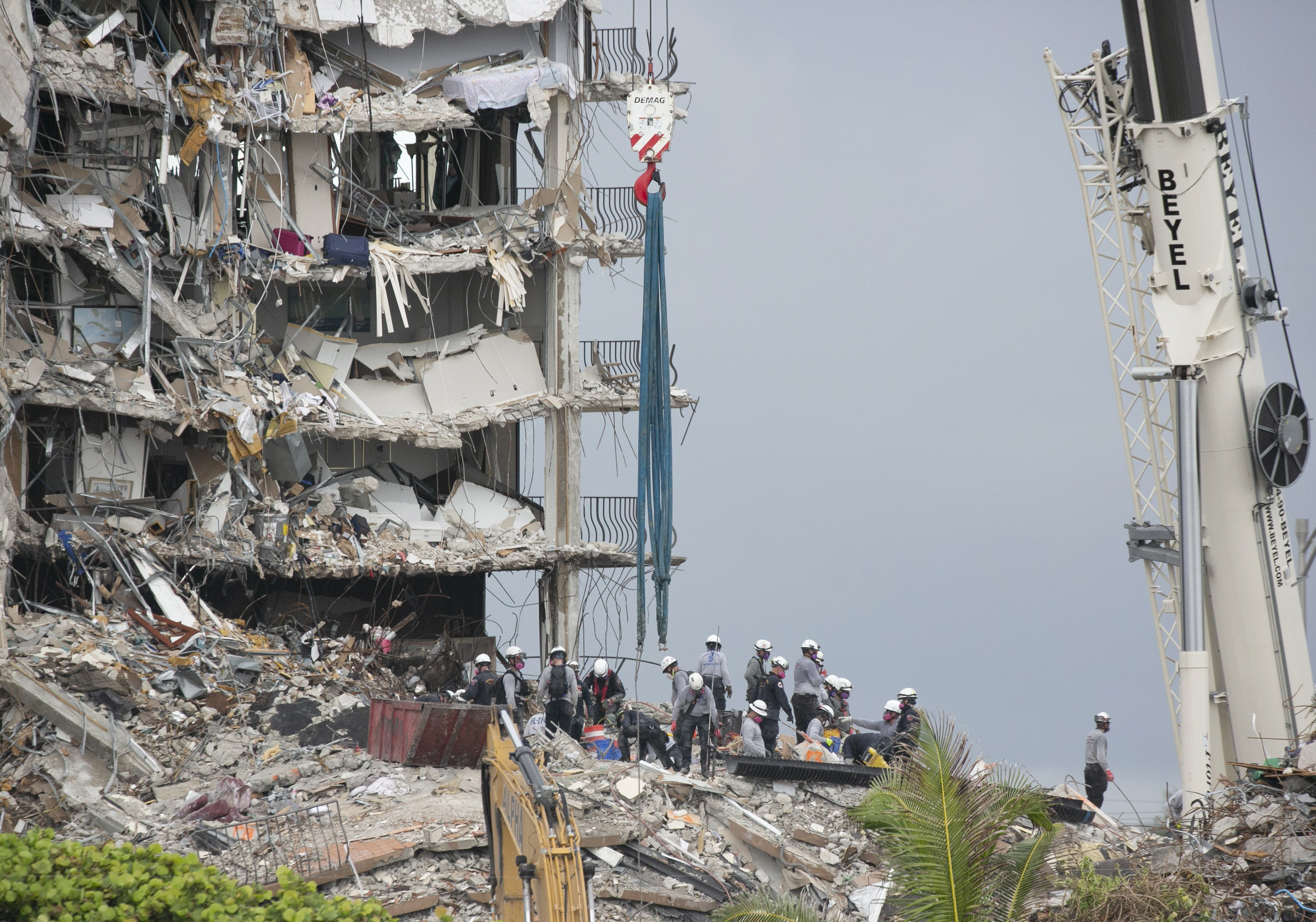 Rescue workers continue to search for survivors in the collapsed building of the Champlain Towers South, Wednesday June 30, 2021, in Surfside, Fla. Crews searching for survivors in the ruins of a collapsed Florida condo tower have built a ramp that should allow the use of heavier equipment, potentially accelerating the removal of concrete that “could lead to incredibly good news events,” the state fire marshal said Wednesday. (Emily Michot/Miami Herald via AP)