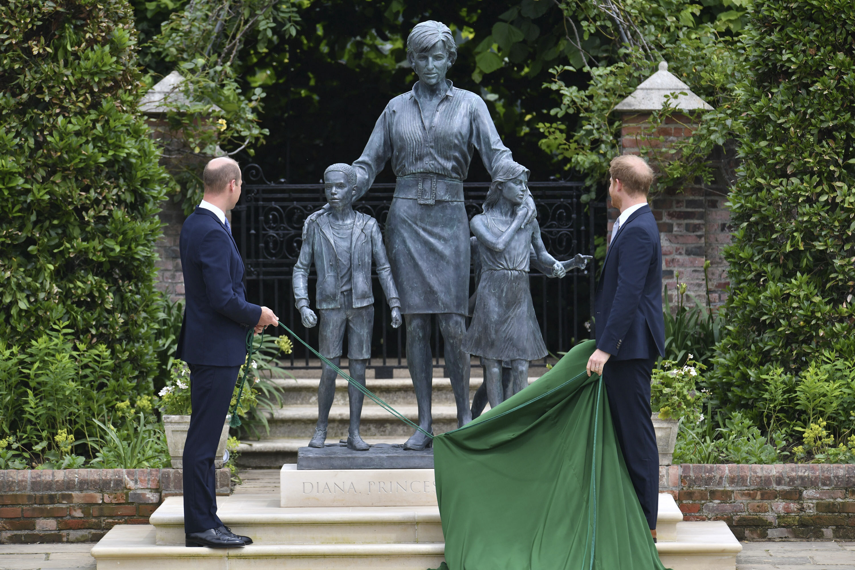 Britain's Prince William, left and Prince Harry unveil a statue they commissioned of their mother Princess Diana, on what woud have been her 60th birthday, in the Sunken Garden at Kensington Palace, London, Thursday July 1, 2021. (Dominic Lipinski /Pool Photo via AP)