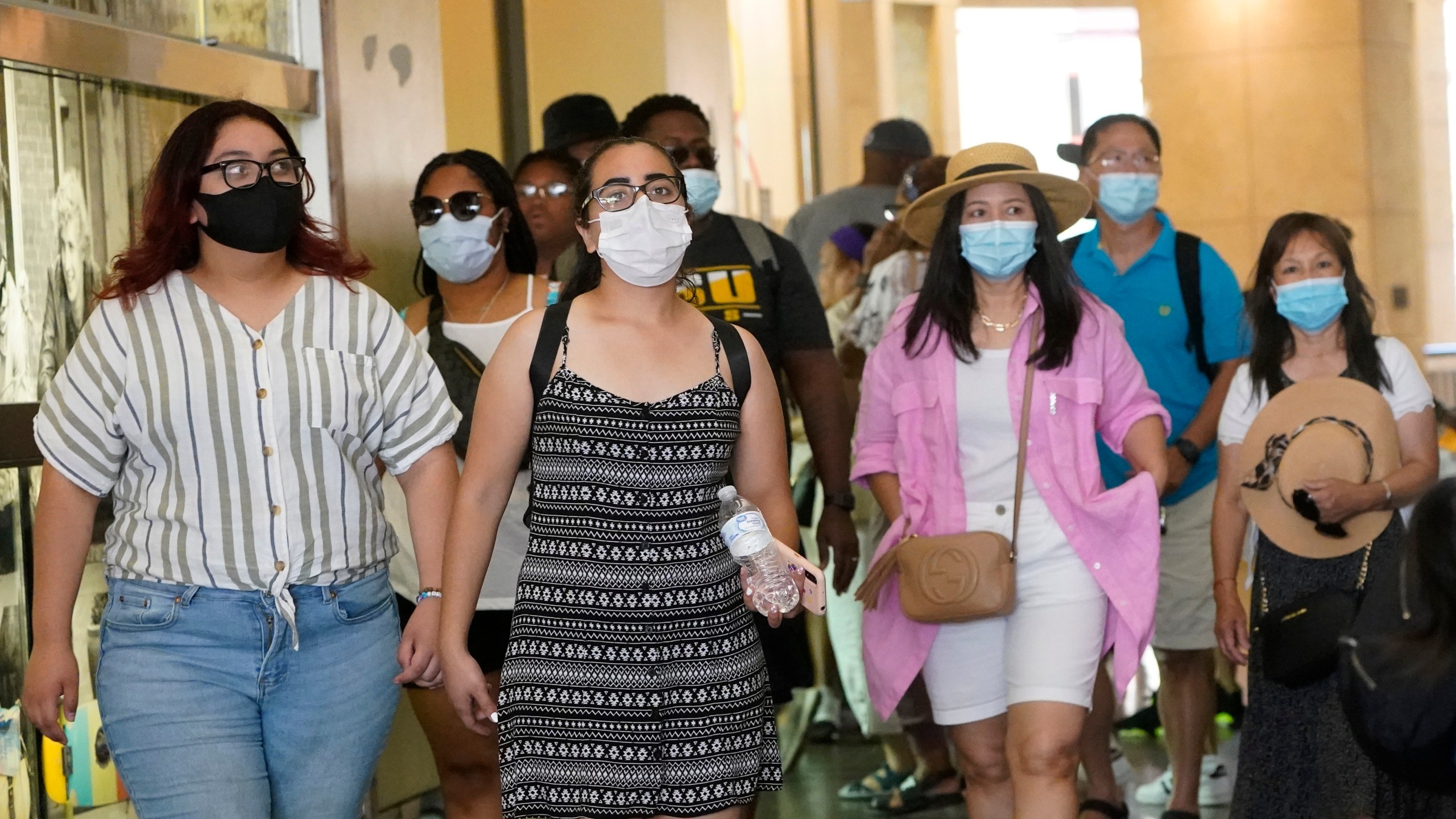 Visitors wear masks as they walk in a shopping district Thursday, July 1, 2021, in the Hollywood section of Los Angeles. (AP Photo/Marcio Jose Sanchez)