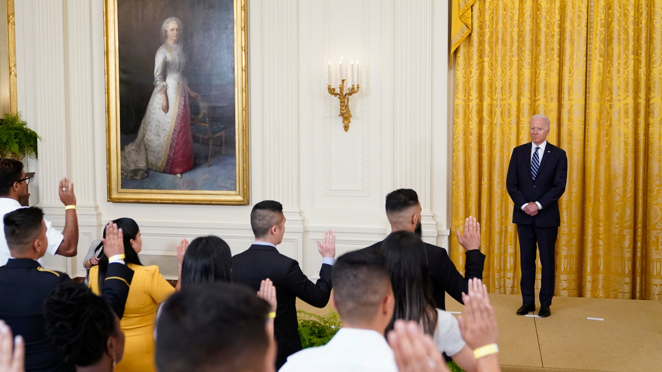 President Joe Biden listens as people take the Oath of Allegiance during a naturalization ceremony in the East Room of the White House, Friday, July 2, 2021, in Washington. (AP Photo/Patrick Semansky)